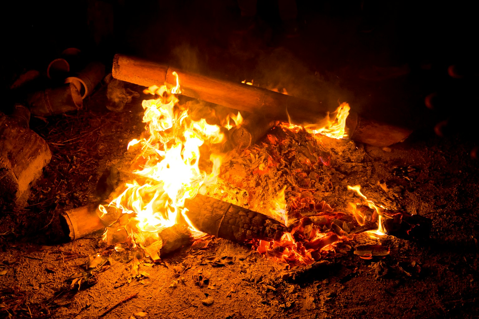 Holz brennt in einem nächtlichen Feuer mit Flammen und Rauch