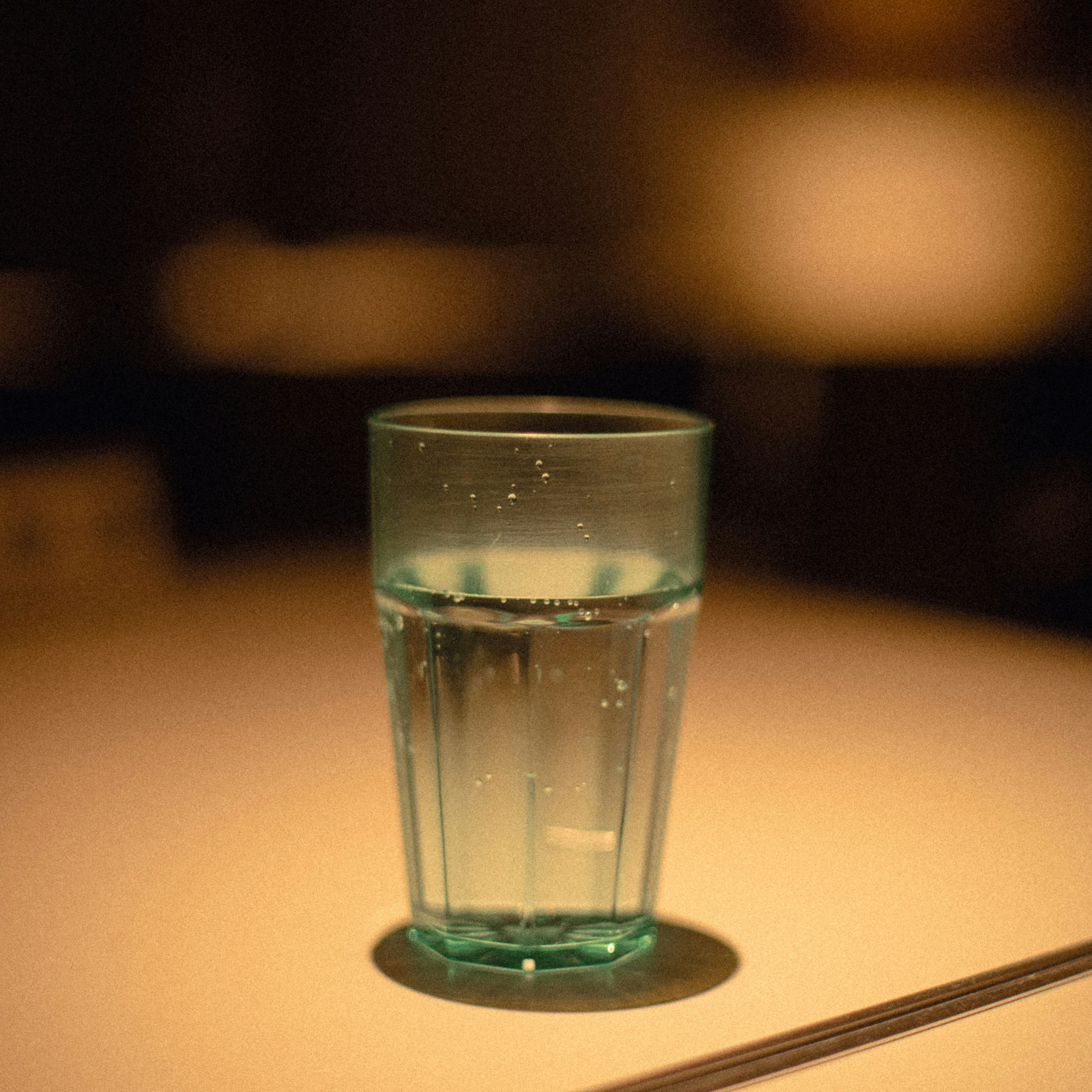 グラスに注がれた水と光のある静かなテーブルシーン