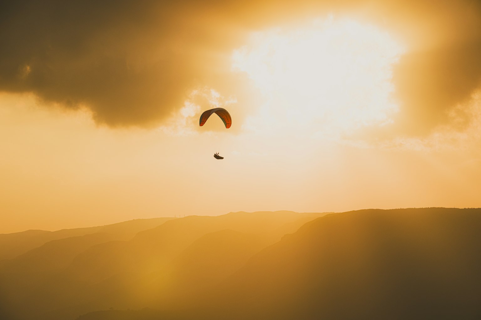 Parapente volant contre un coucher de soleil