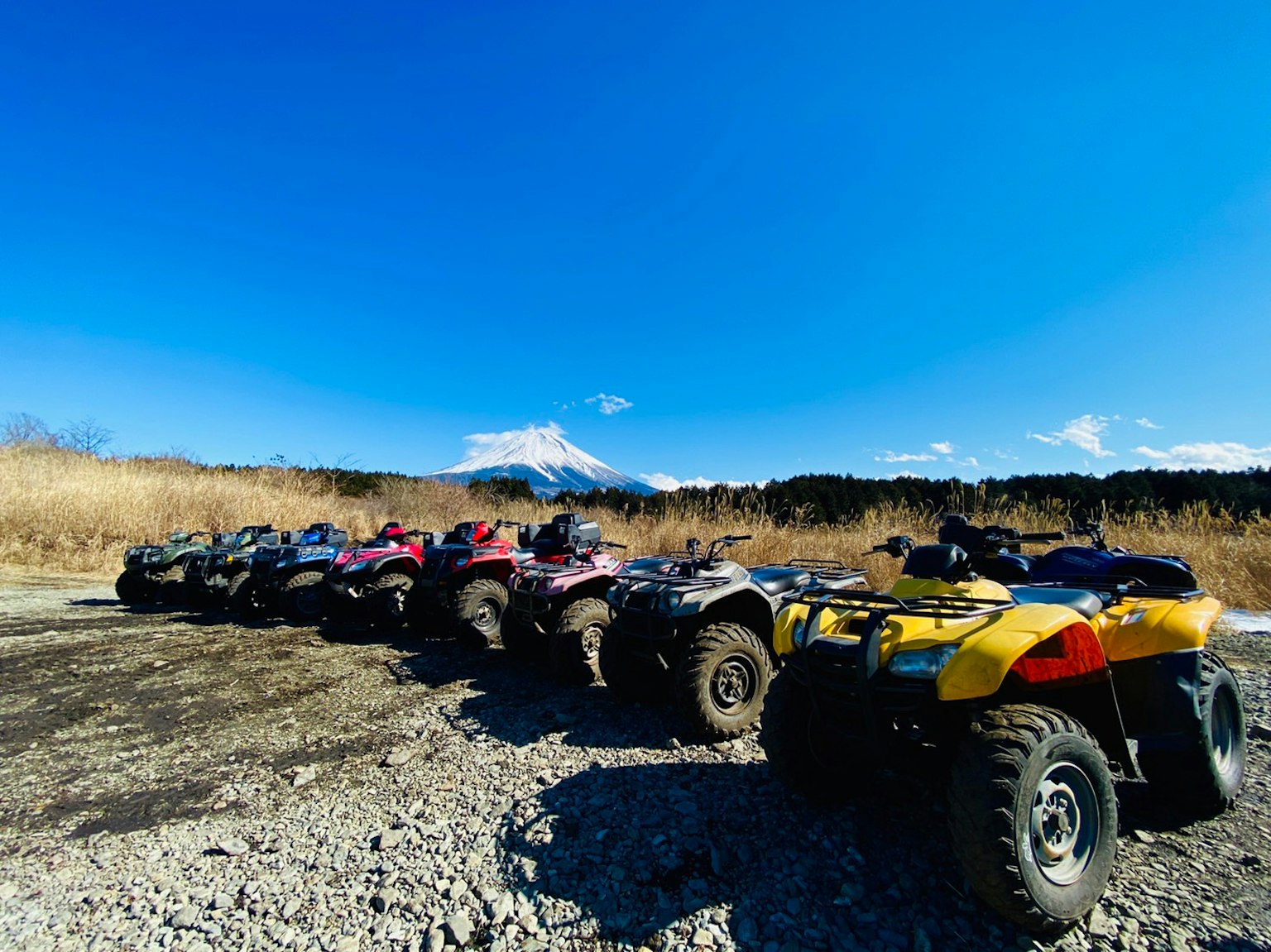 Rangée de quads sous un ciel bleu avec le mont Fuji en arrière-plan