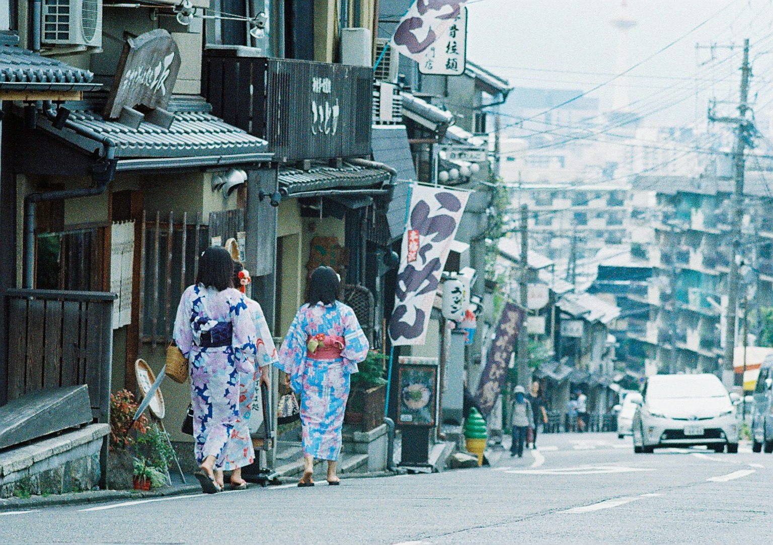 Two women walking in traditional yukata on a street