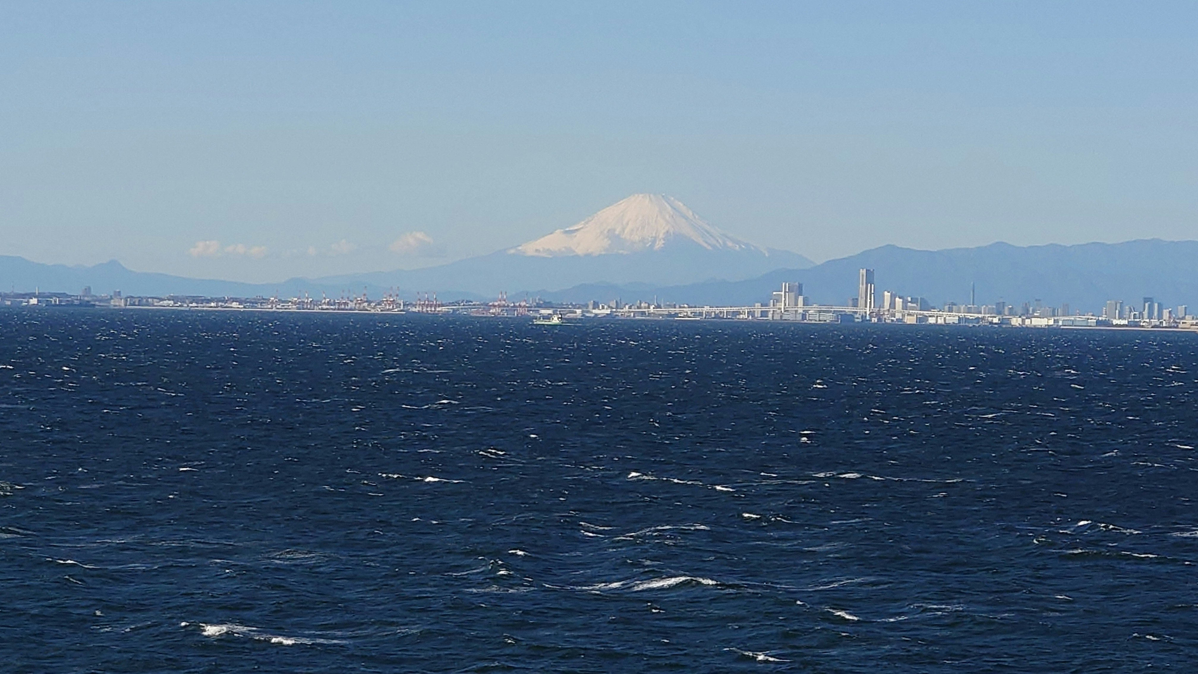 東京湾の海上から見える富士山とベイブリッジ