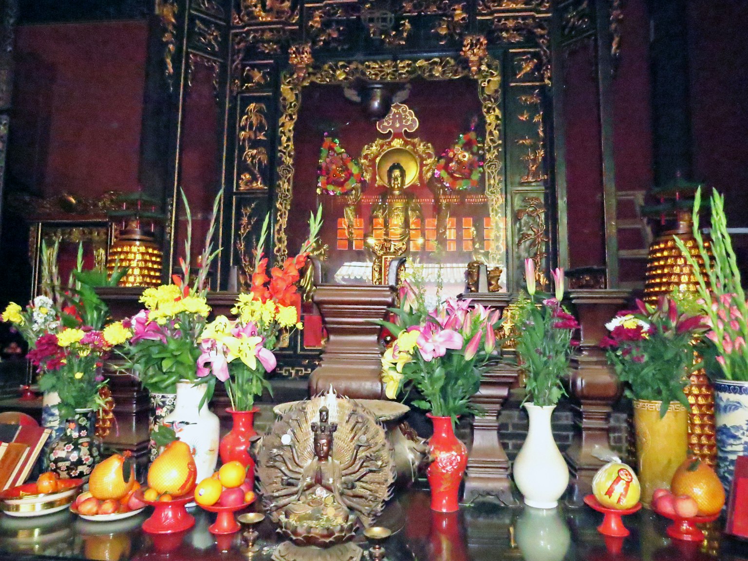 一个生动的祭坛，上面有佛像和五彩缤纷的花朵及供品