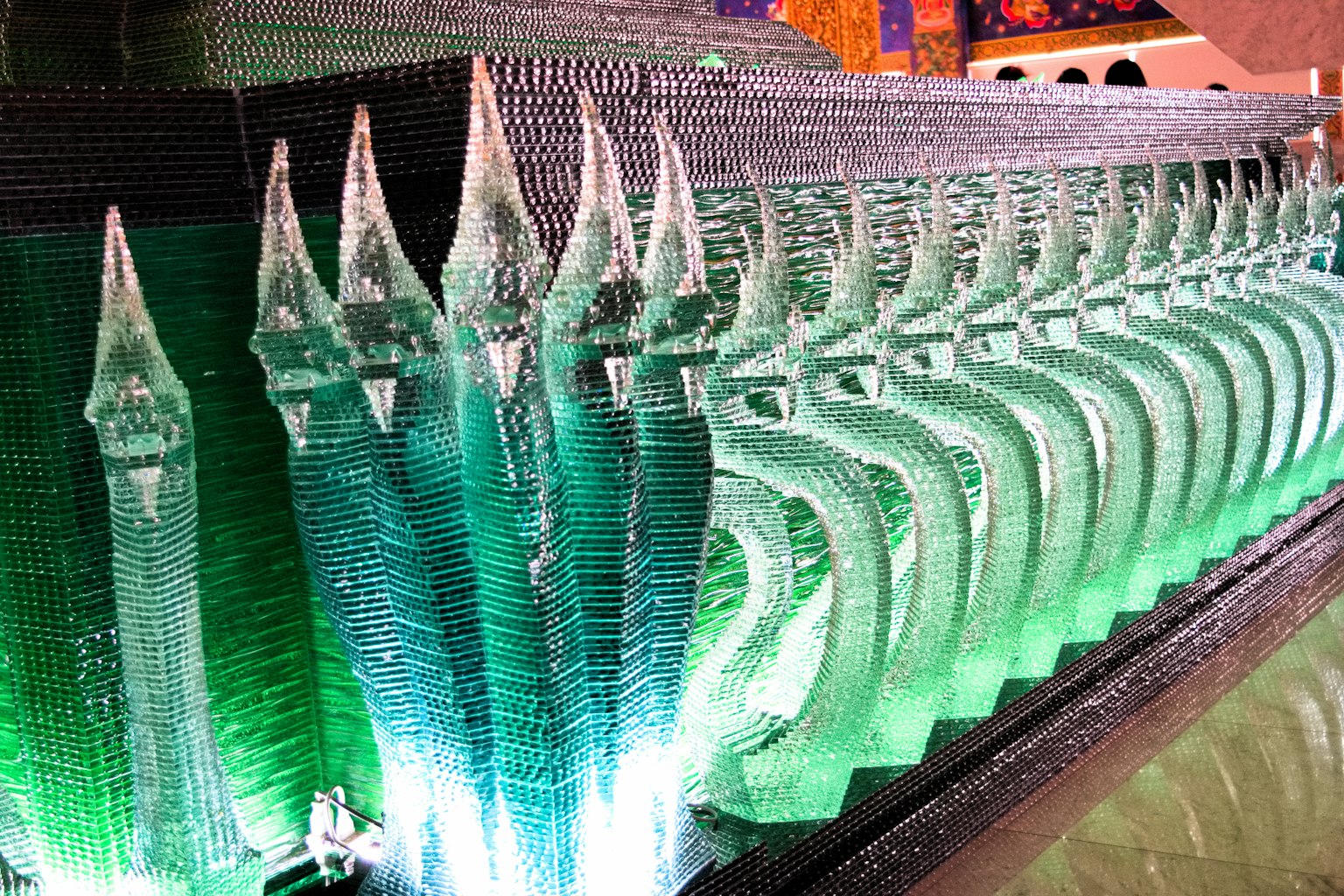 แถวแกะสลักน้ำแข็งที่มีการตกแต่งด้วยแสงสีเขียว