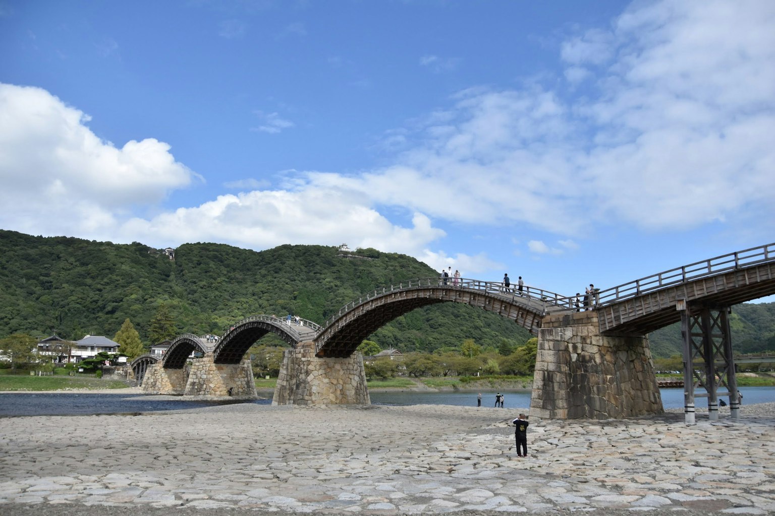 Beau pont en arc avec des montagnes et une rivière en arrière-plan