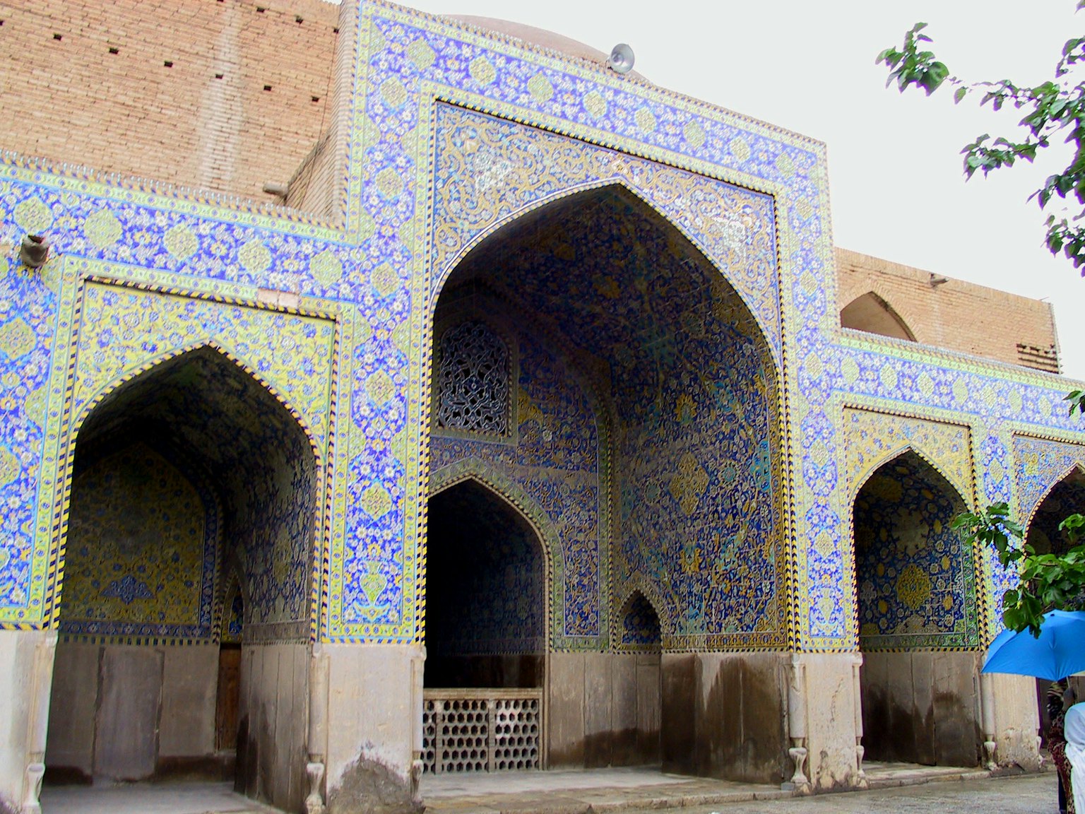 Building with arched entrance decorated in blue and yellow tiles