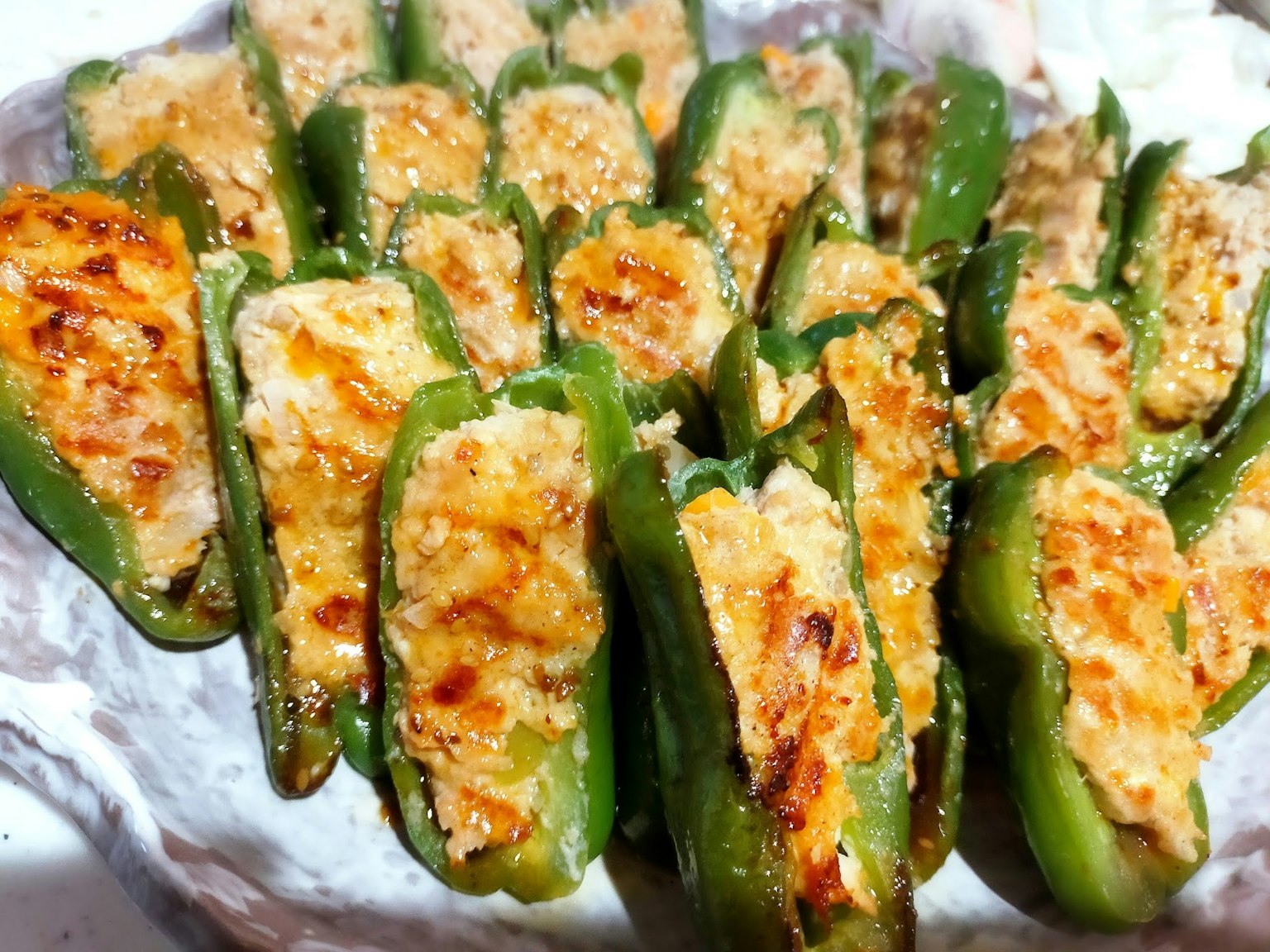 Baked jalapeño slices stuffed with a savory filling