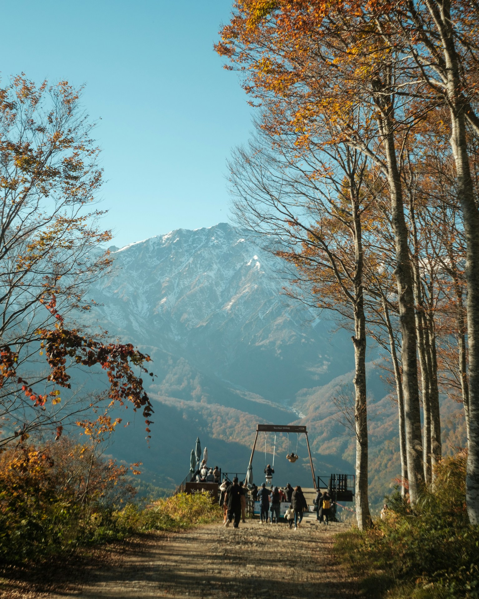 Paysage de montagne entouré d'arbres d'automne avec des personnes