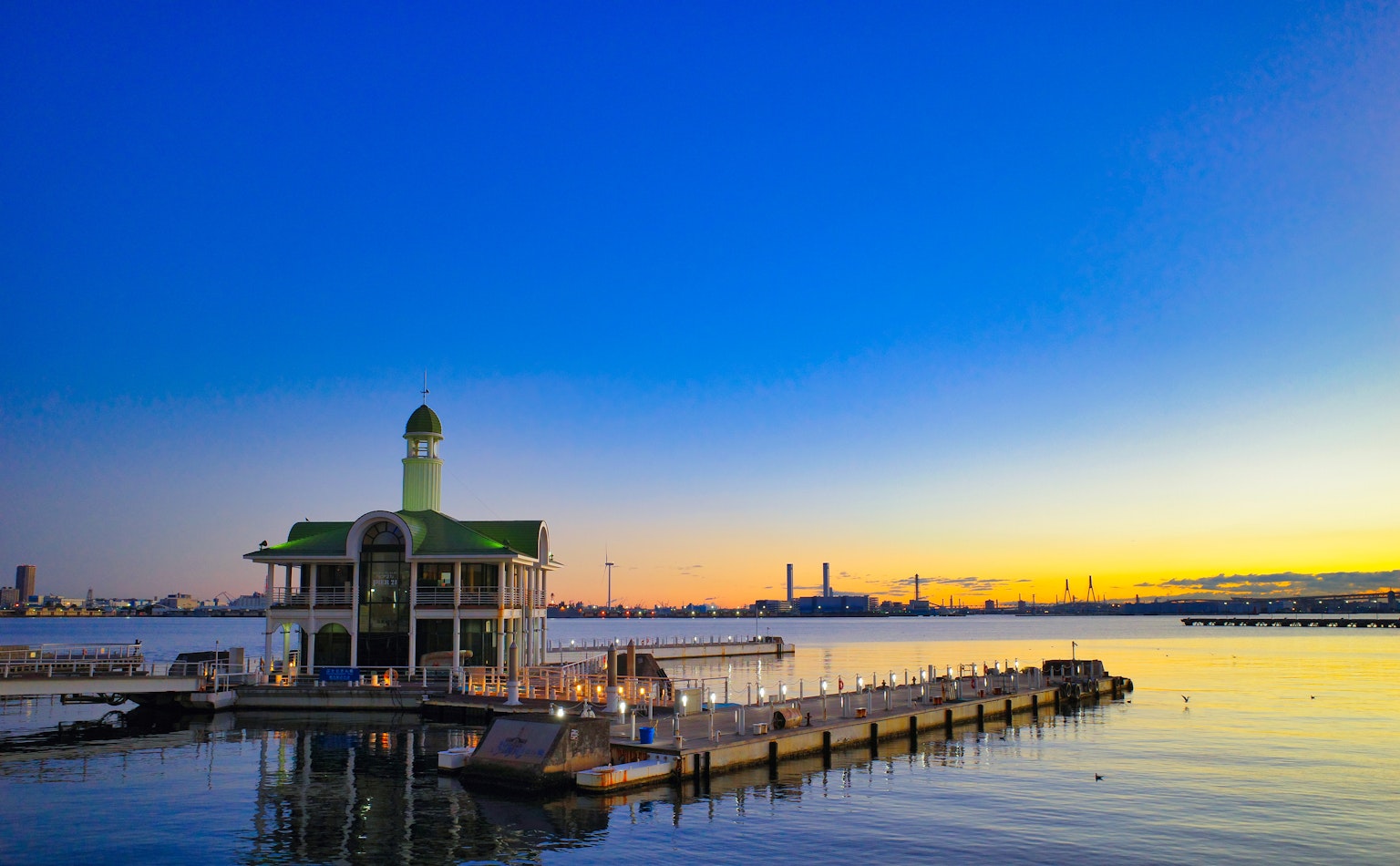 Edificio con techo verde en un muelle durante el atardecer