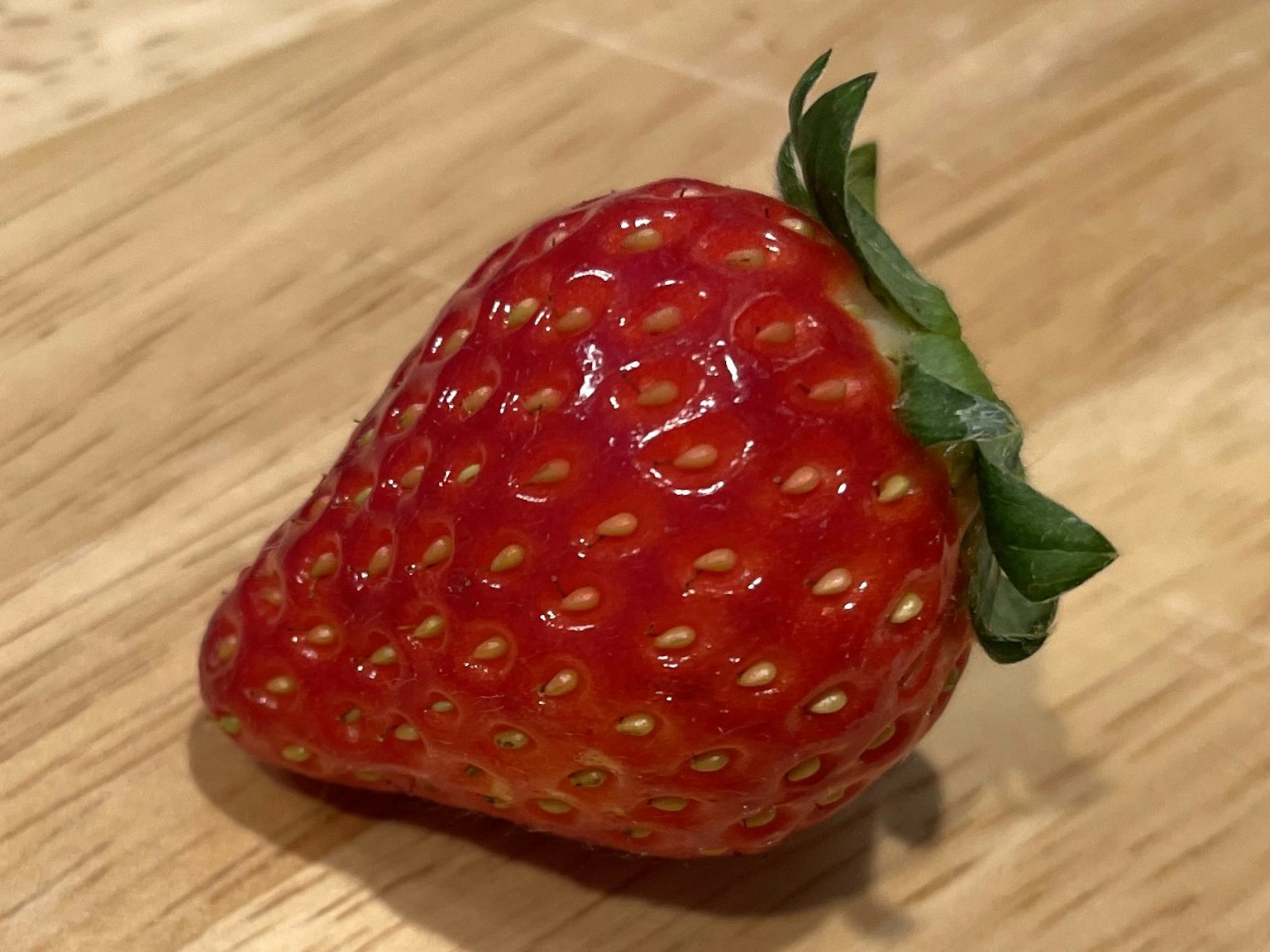 Una fragola fresca su un tavolo di legno