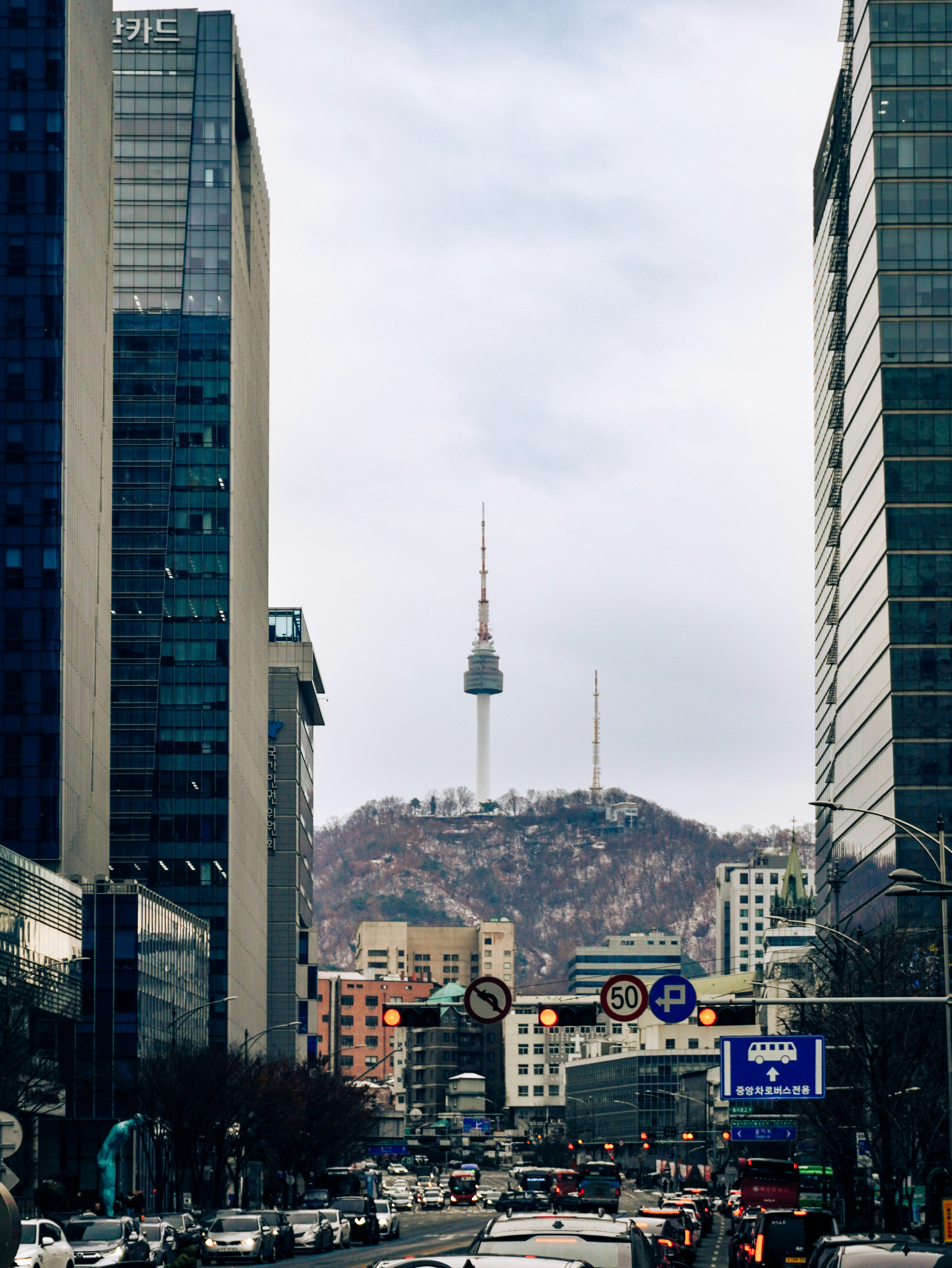 高層ビルの間を走る大通りと遠景のタワー