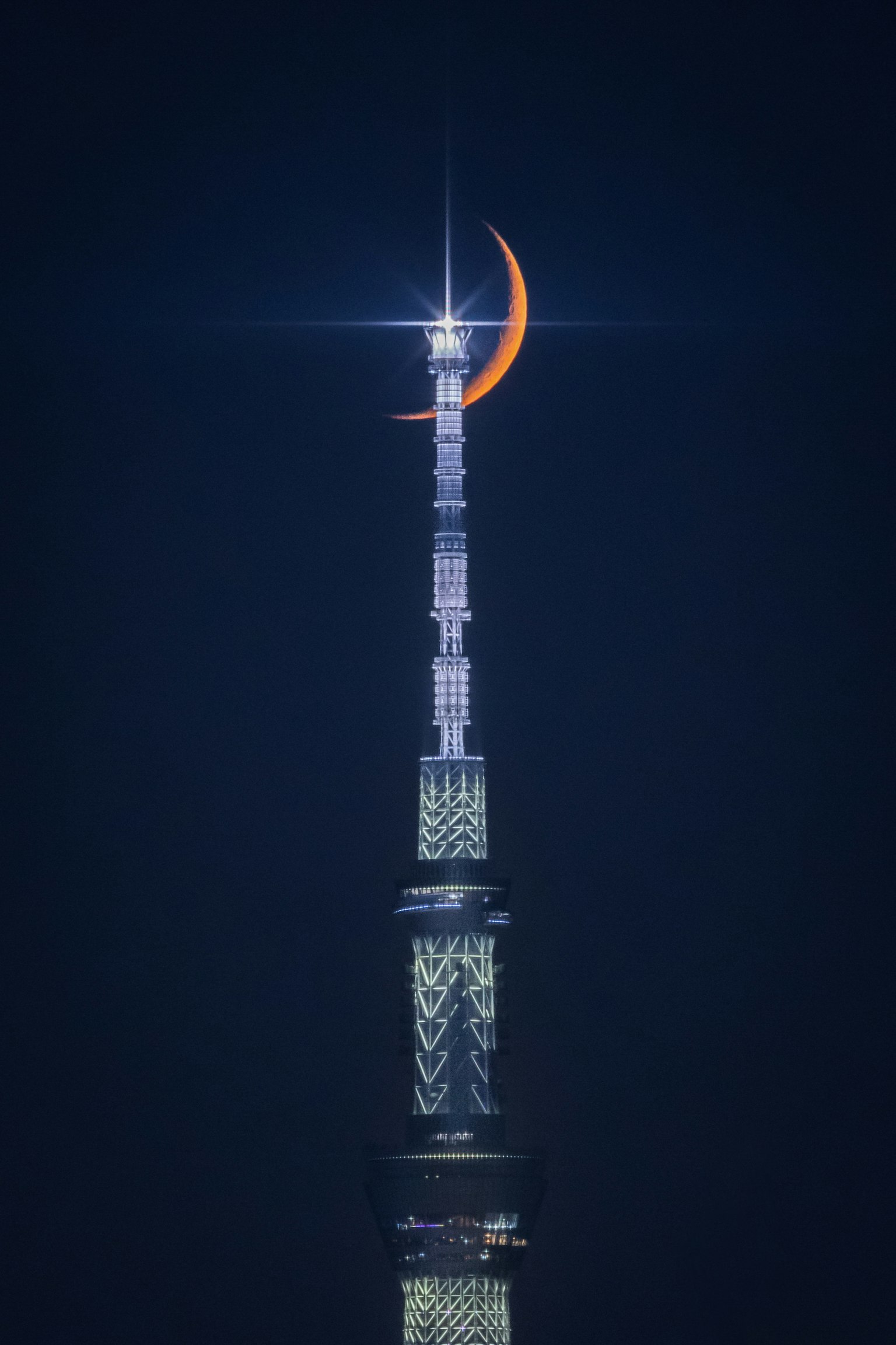 東京晴空塔頂端的月牙輪廓與閃爍的星星