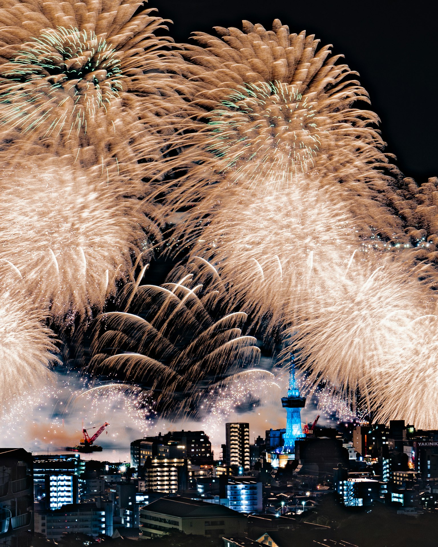 Hermosos fuegos artificiales iluminando el cielo nocturno sobre un paisaje urbano