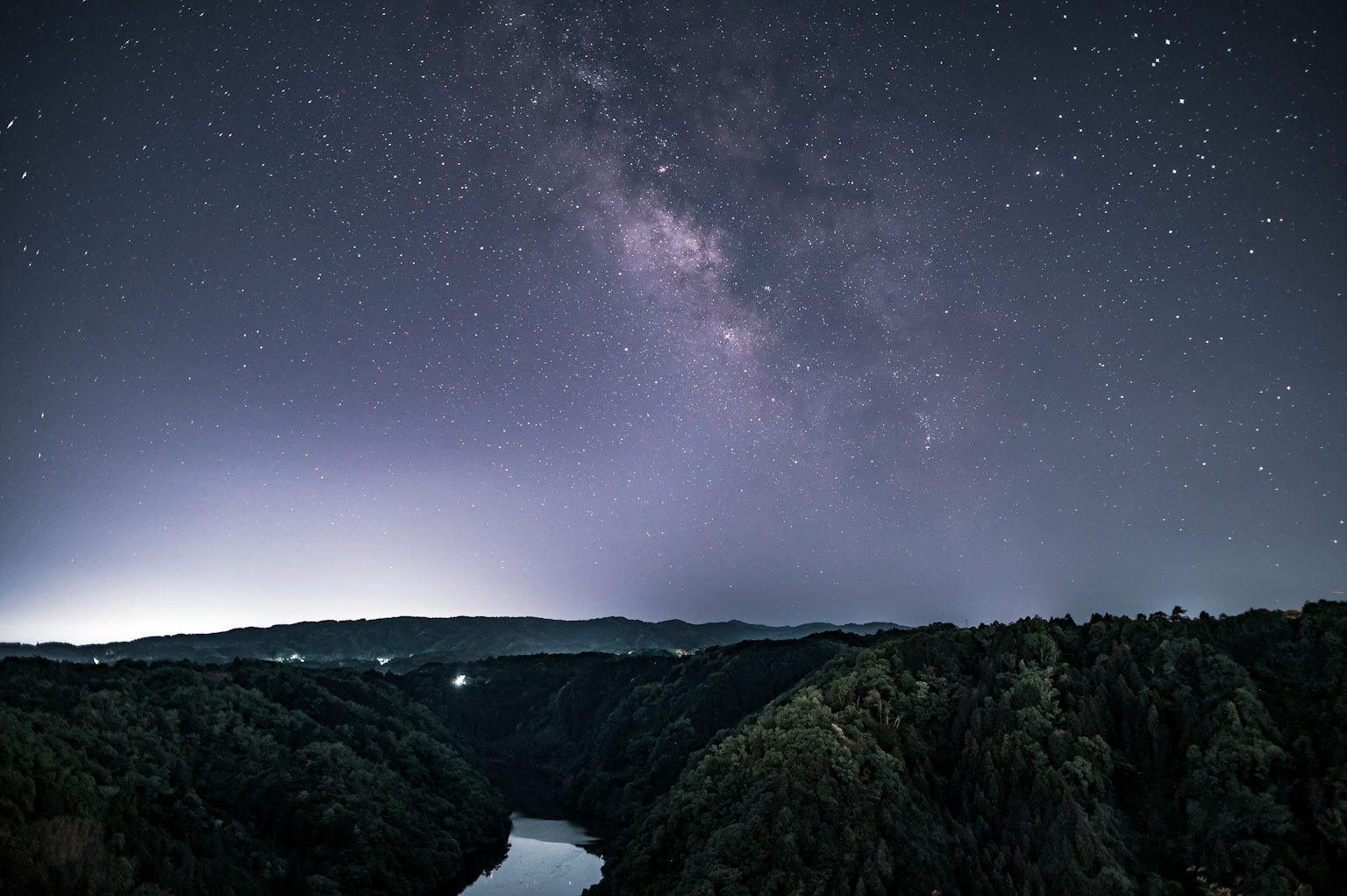Ciel nocturne magnifique avec la Voie lactée visible au-dessus des montagnes et d'une rivière