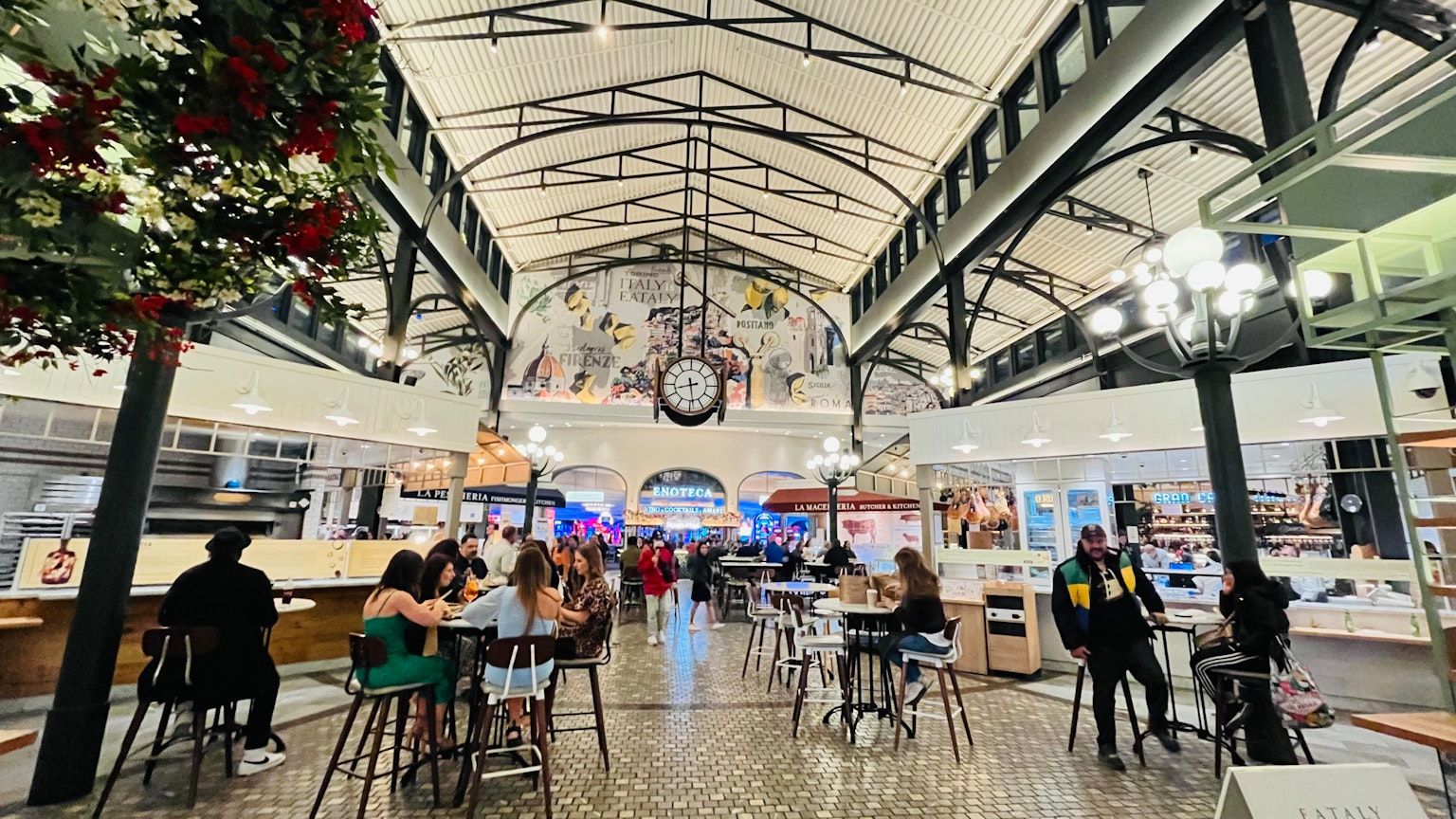充滿活力的食品市場內部 各種人們用餐 高高的天花板和裝飾性照明是顯著特徵