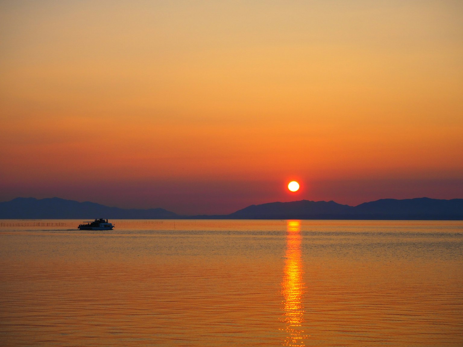 Schöner Sonnenuntergang über dem Meer mit einem sanft schaukelnden Boot