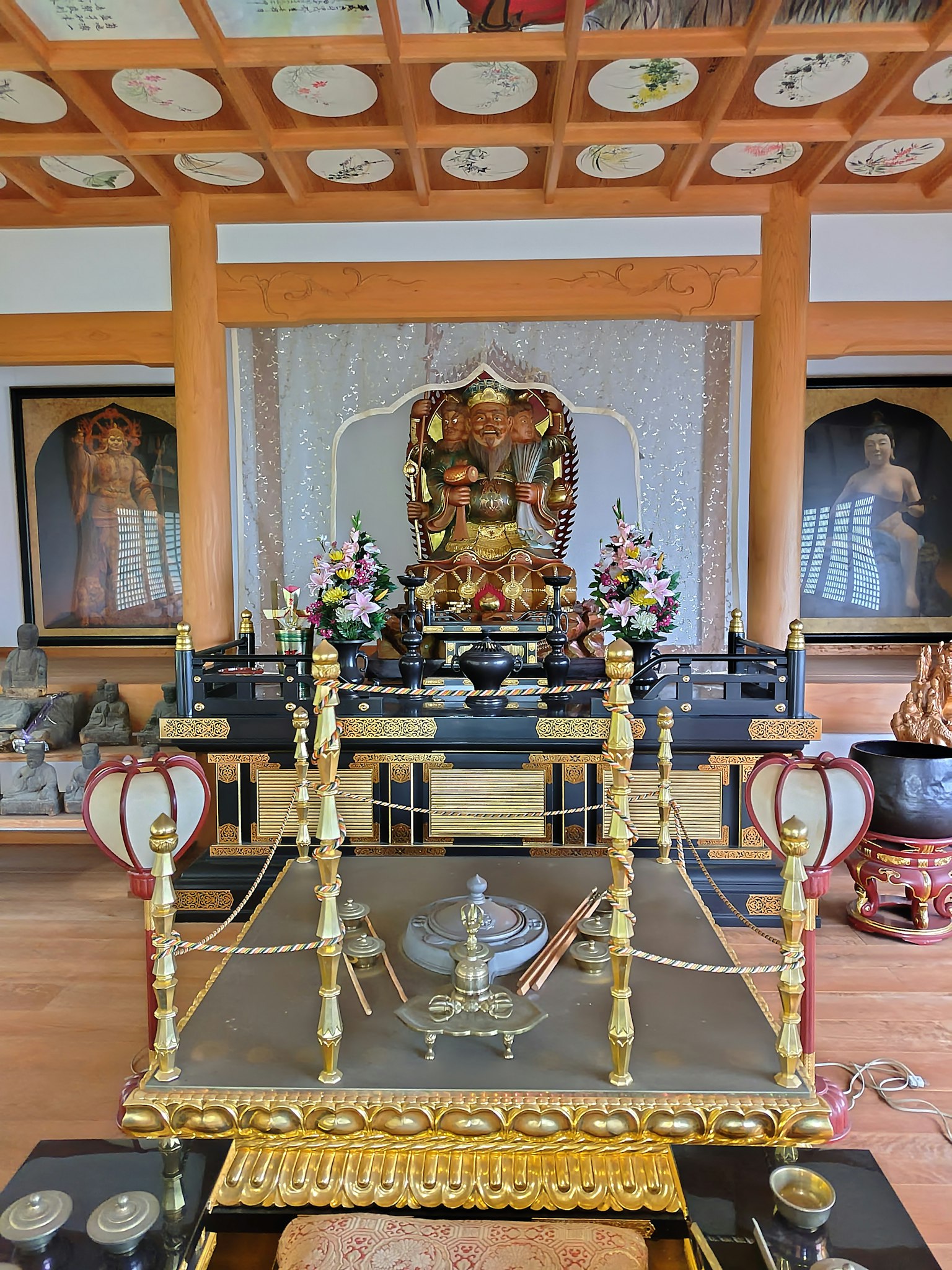 Interior view featuring an ornate altar with a statue and floral arrangements