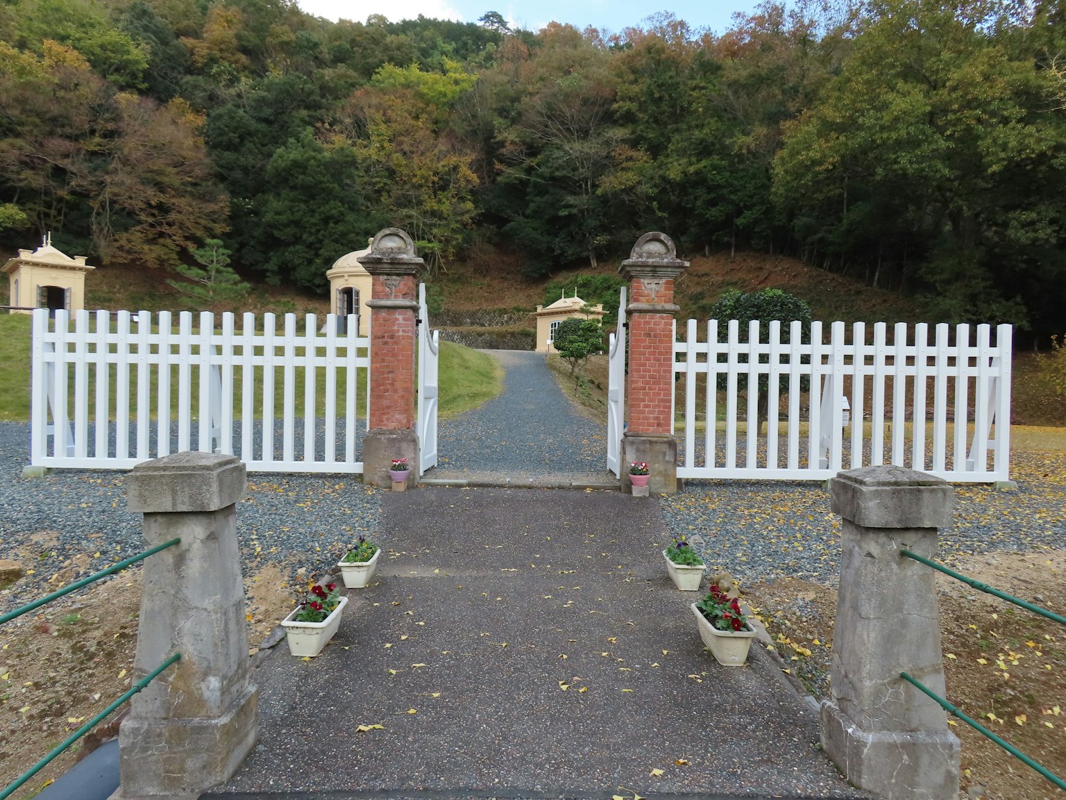 Eingang zu einem ruhigen Garten mit weißem Zaun und Steg