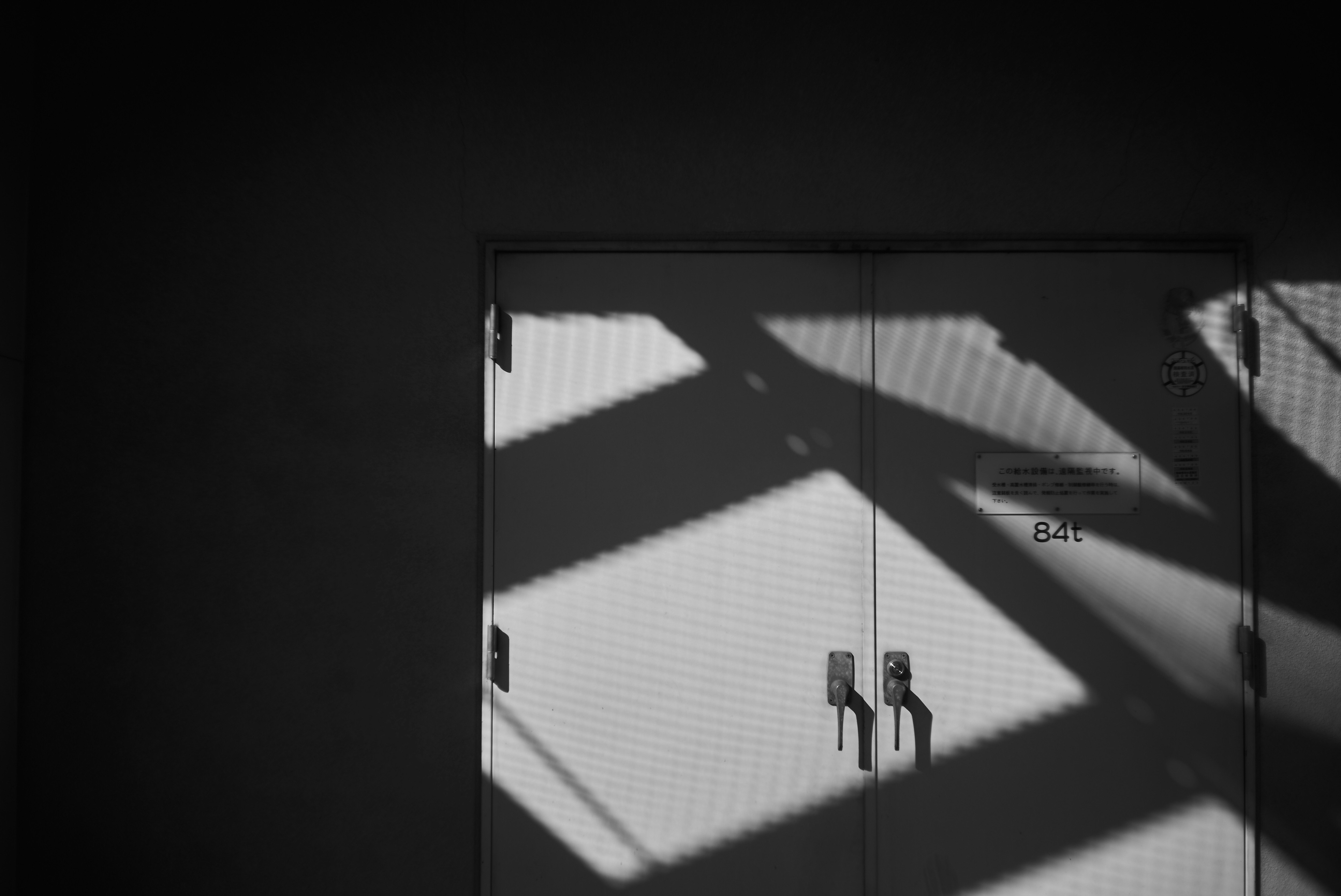 Interior wall seen through a window with strong shadows