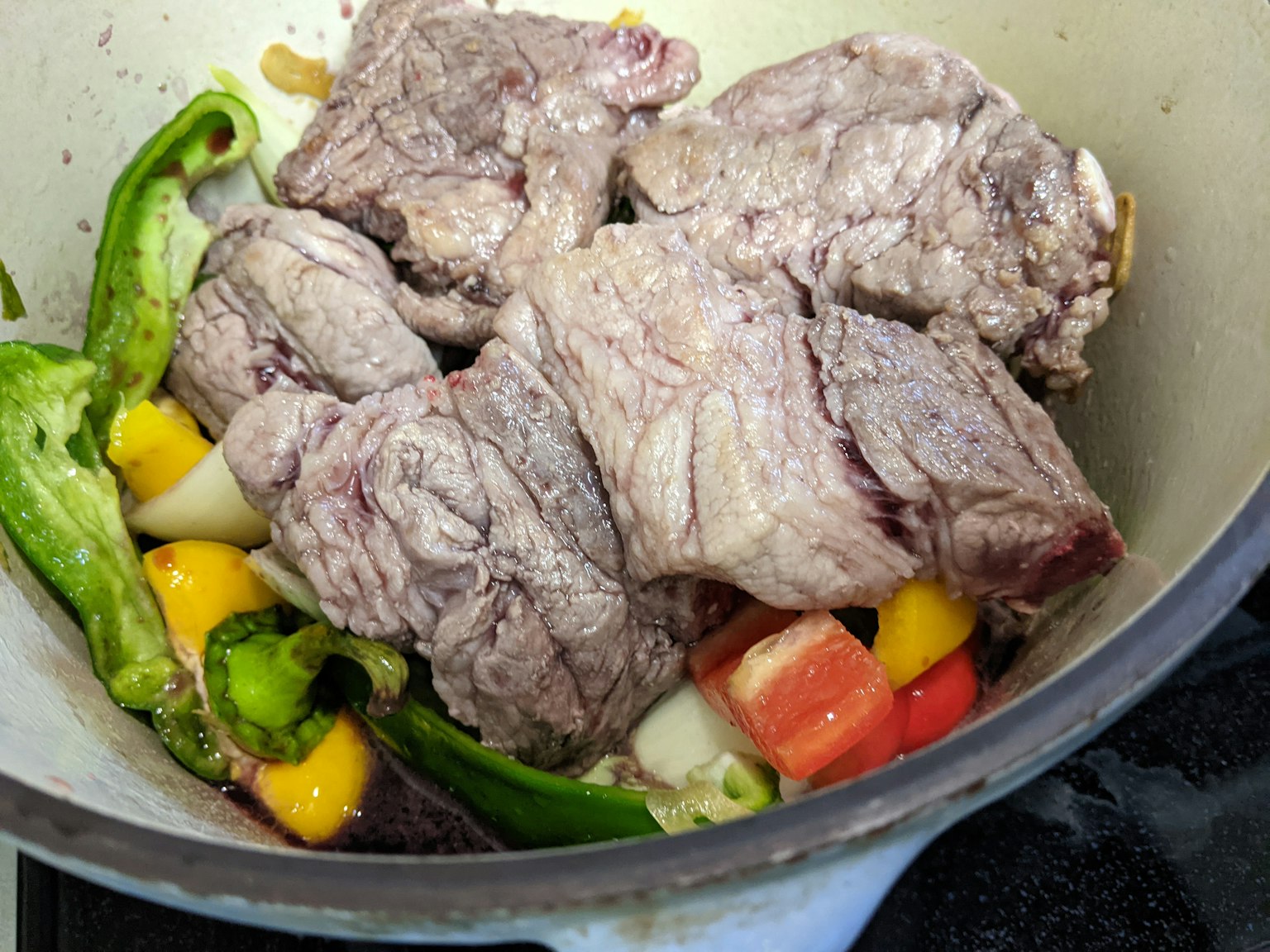锅中放着肉块和五颜六色的蔬菜
