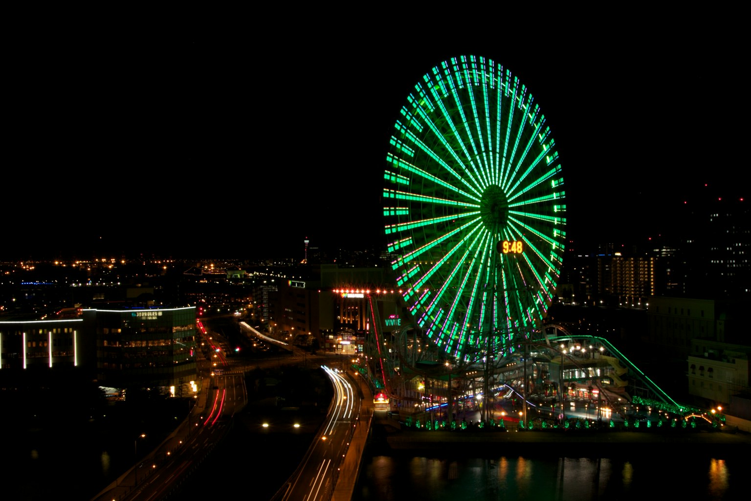 Vue nocturne d'une grande roue illuminée en vert