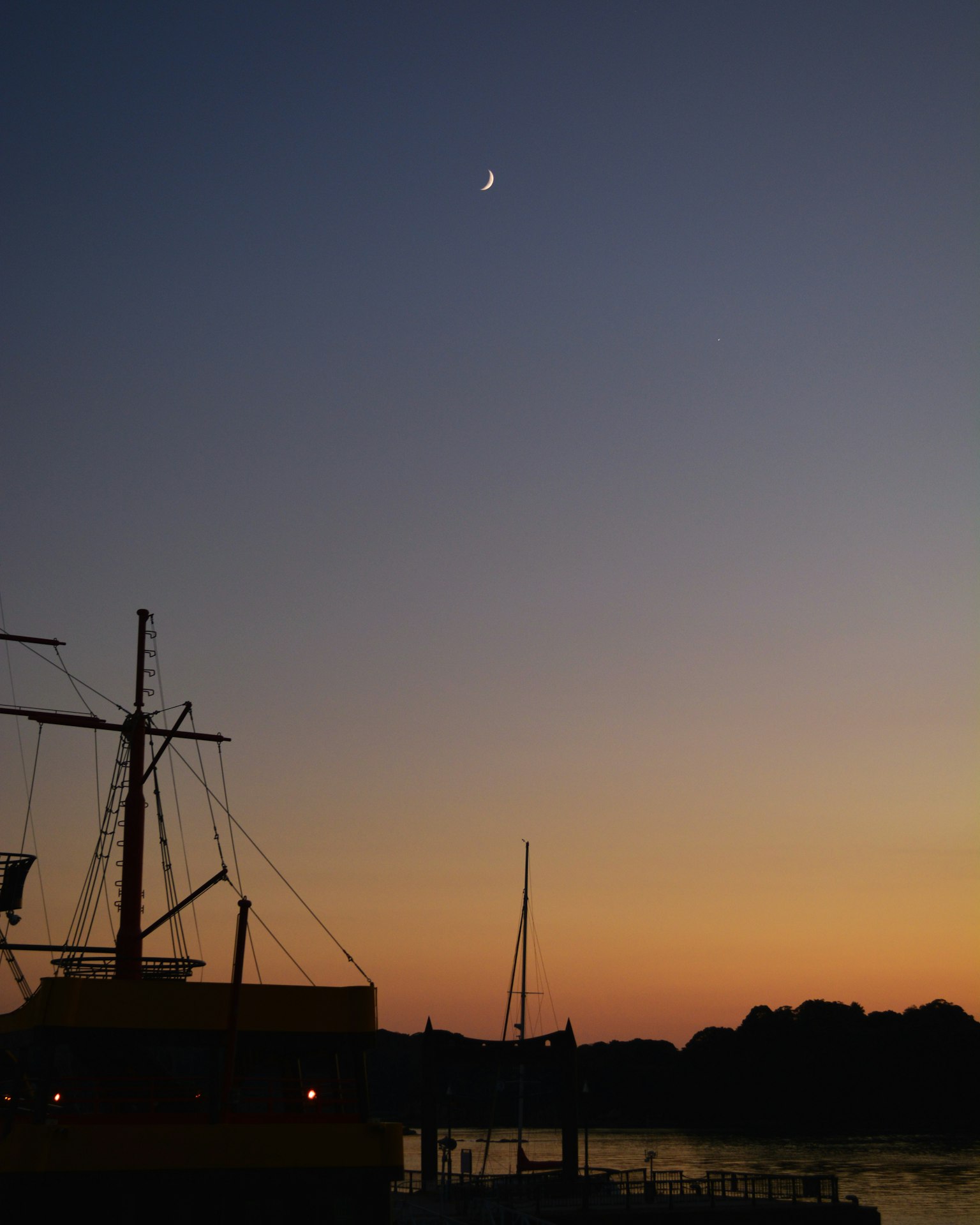 夕阳下的船和新月的美丽场景