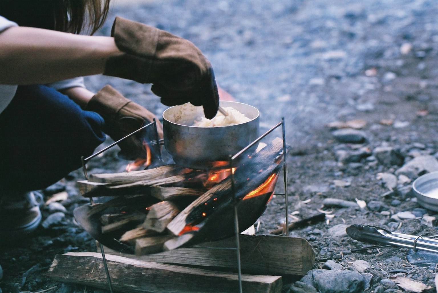 Người đang nấu ăn trên lửa trại với một cái nồi