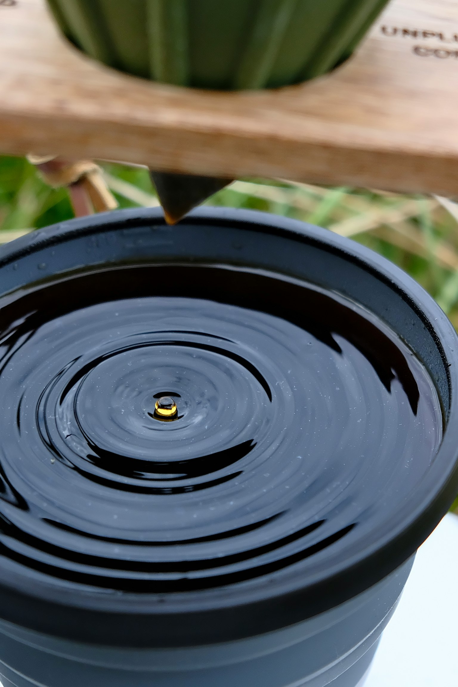 Schwarzer Topf mit welliger Wasseroberfläche und einem goldenen Punkt