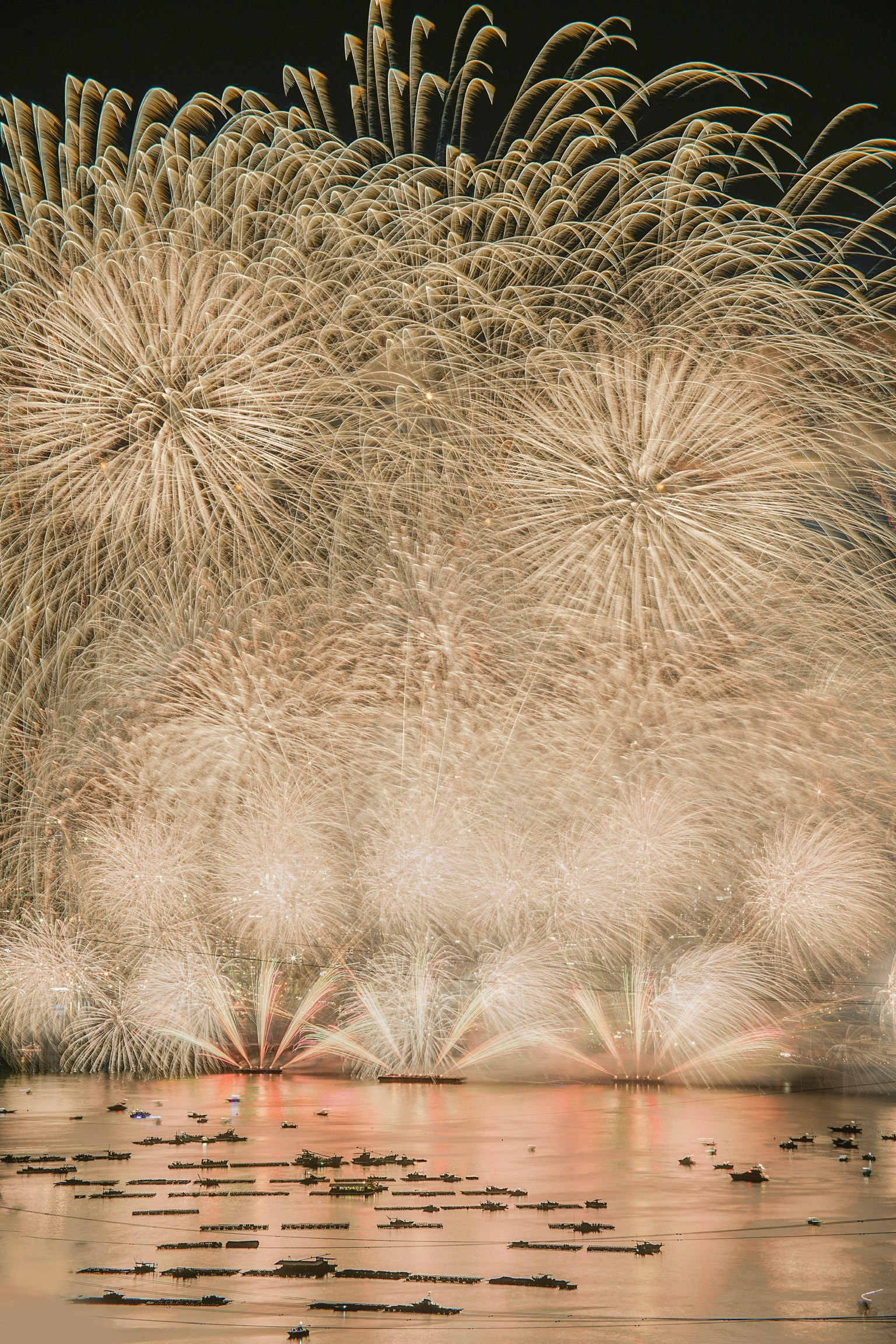 A stunning display of fireworks lighting up the night sky reflections on the water