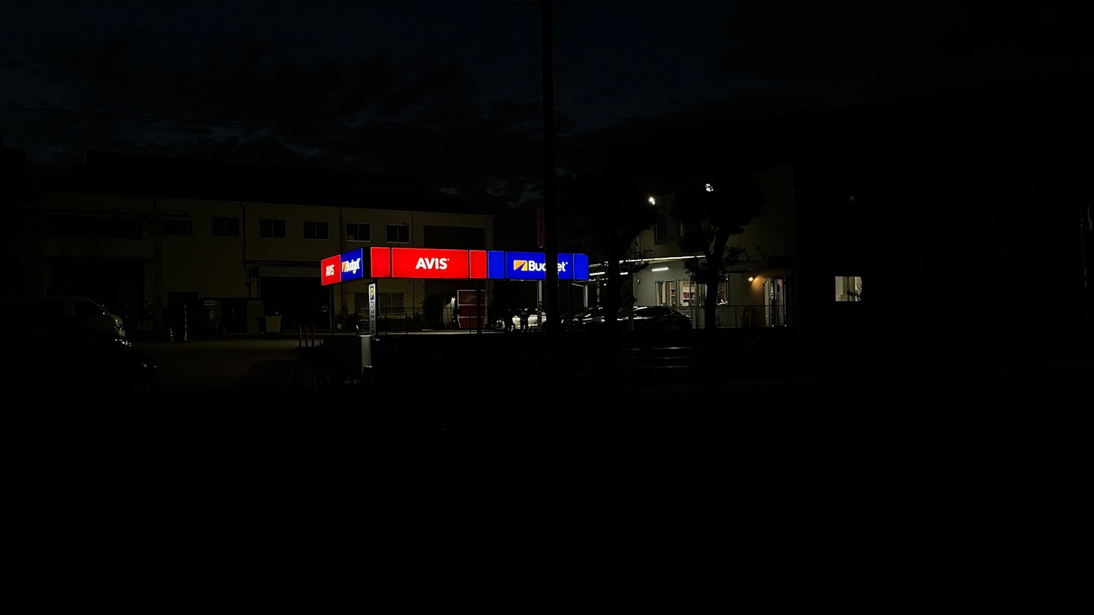 Helle Ladenfront bei Nacht mit bunten Schildern