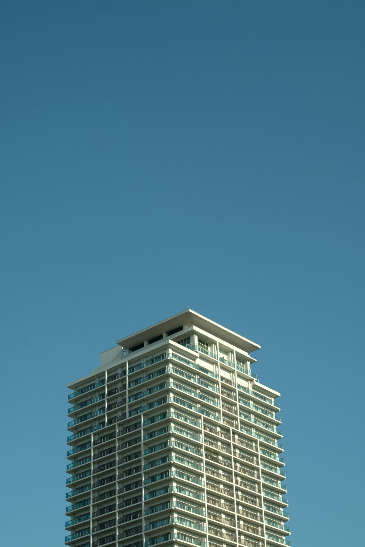 青空の下にそびえる高層マンションの外観