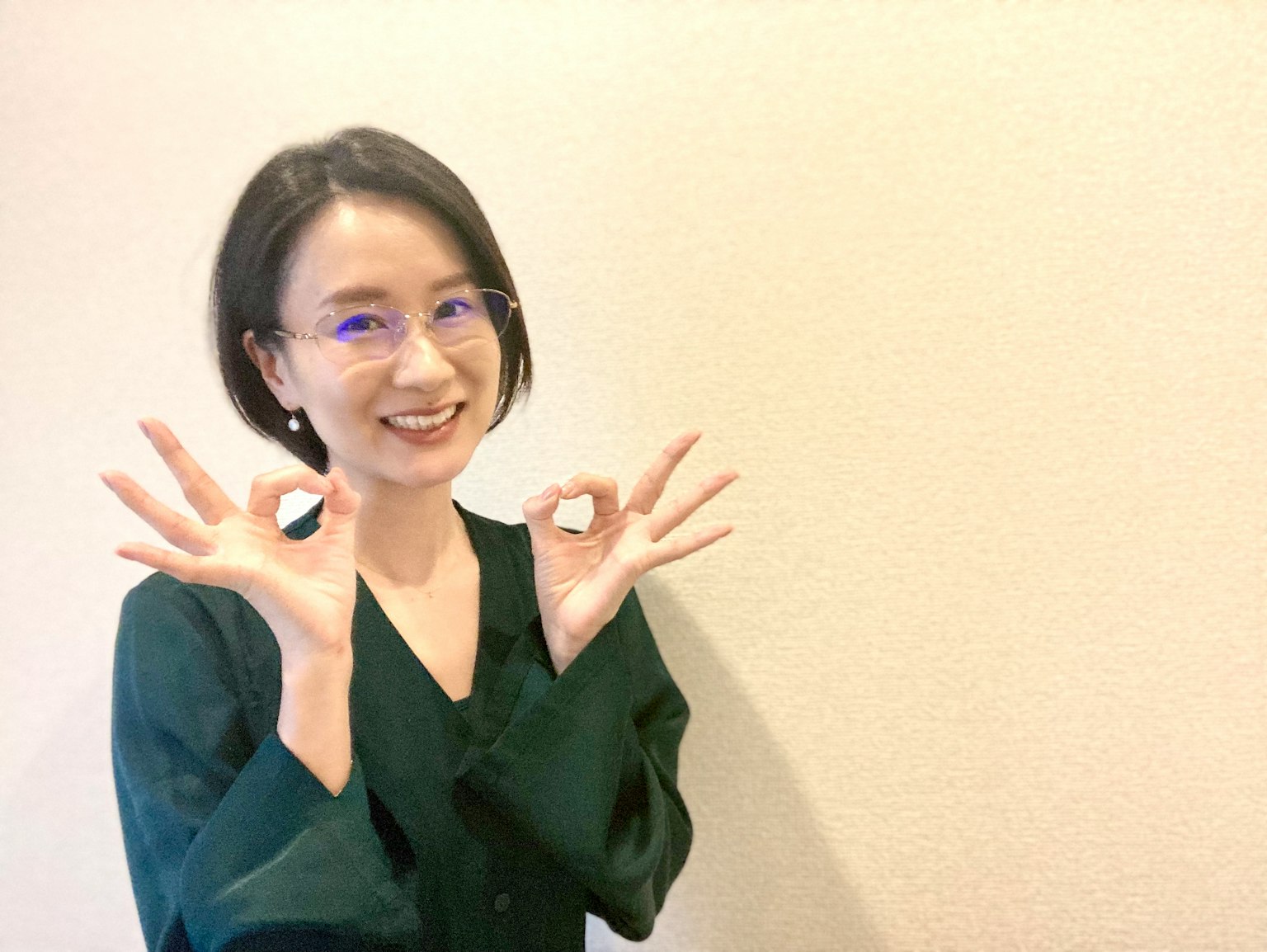 Una donna con una blusa verde che sorride e fa gesti con le mani