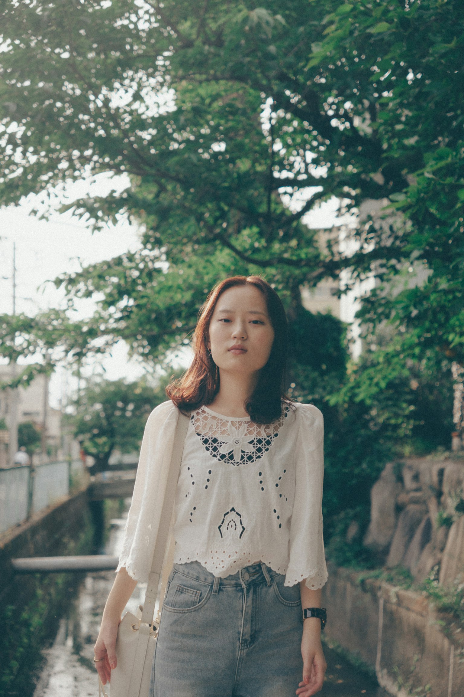 一位女性在綠樹間沿著小路行走