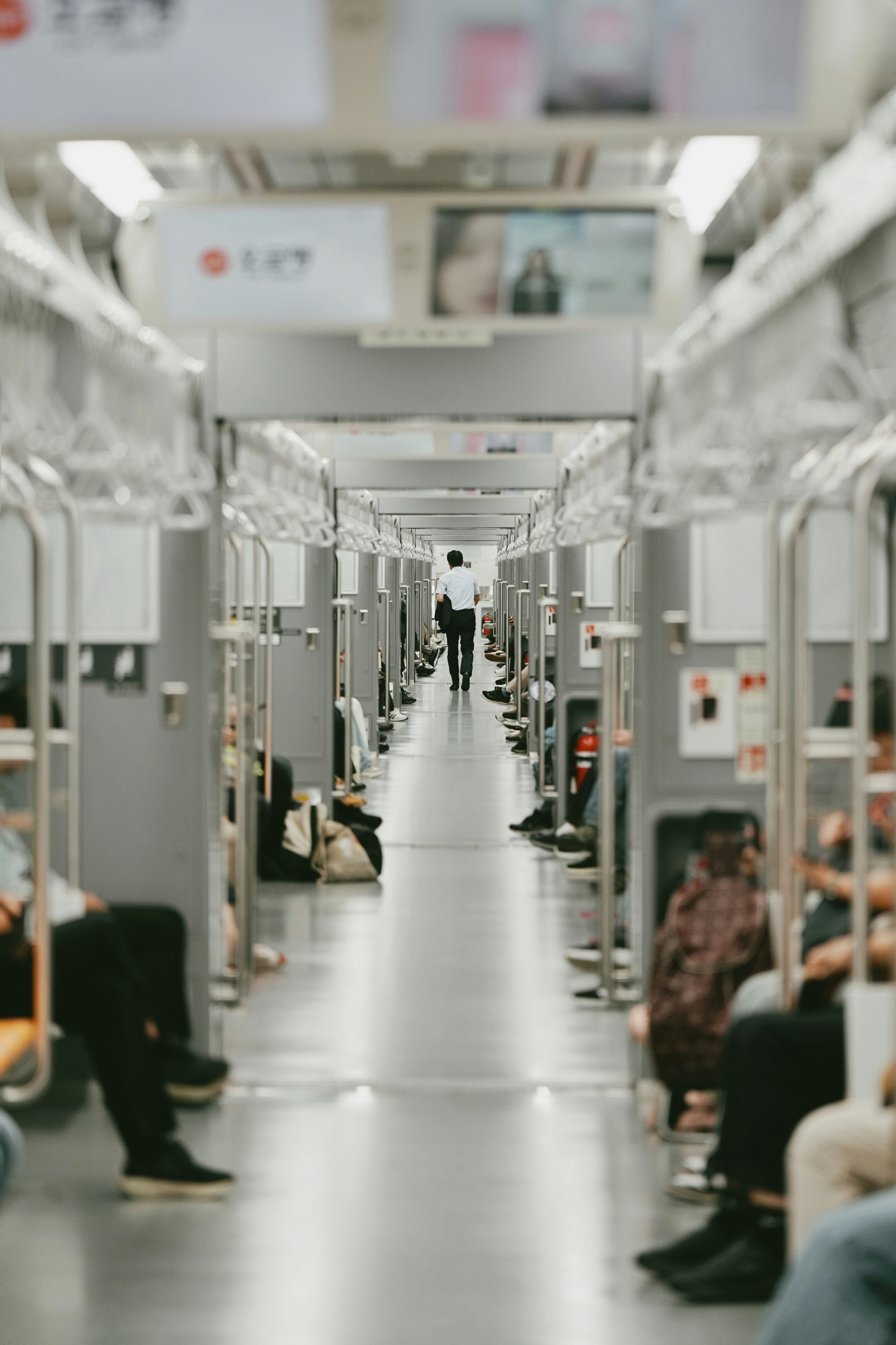 白い廊下に並ぶ棚と人のいる室内通路