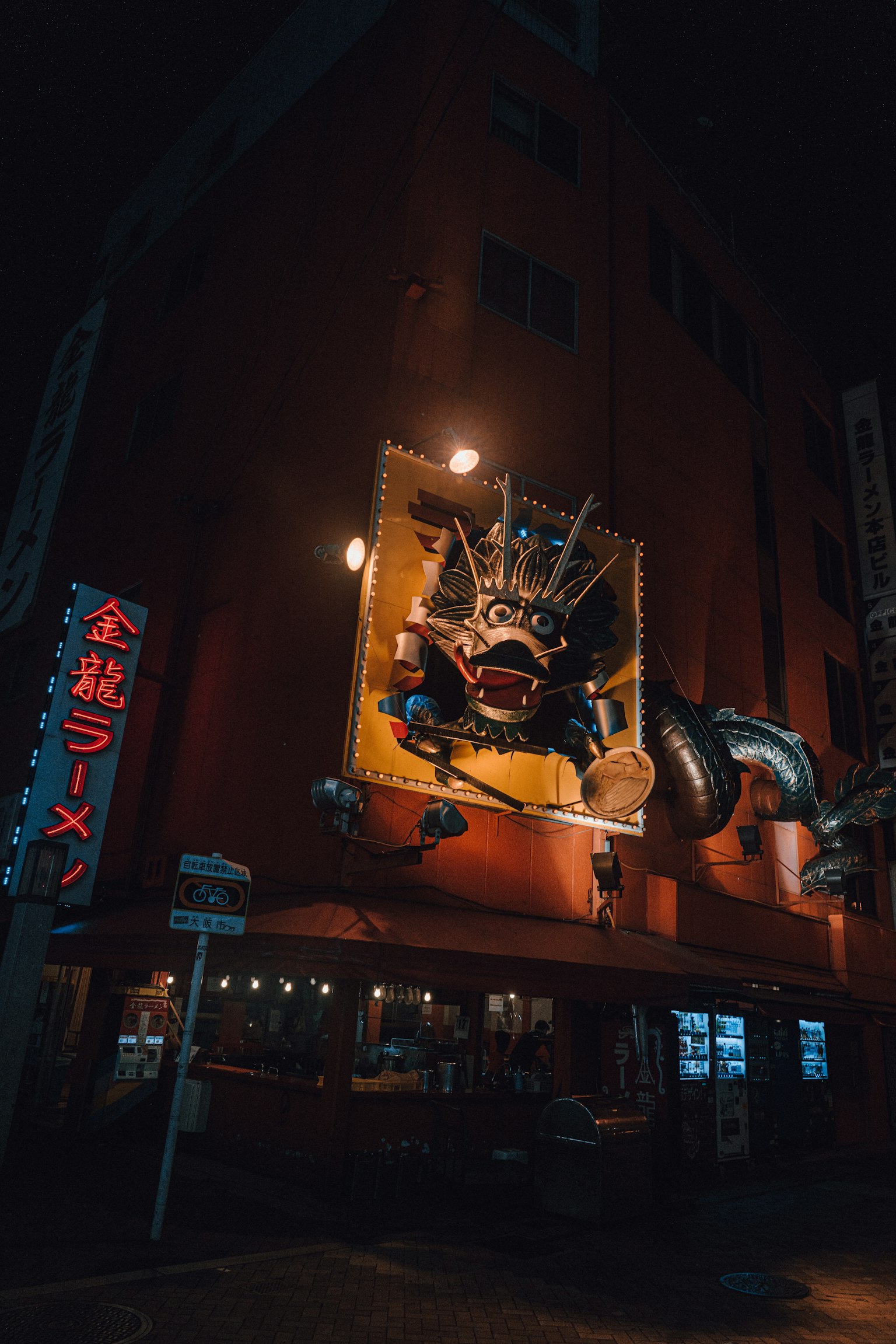 夜景中的拉面店，特色是龙雕塑和霓虹招牌