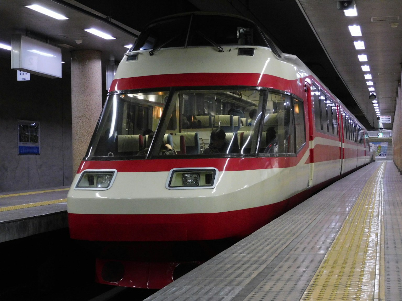 Treno rosso e bianco fermo in una stazione sotterranea