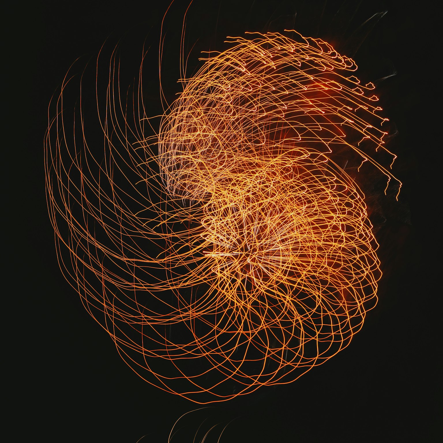 An abstract art piece featuring swirling orange light against a dark background