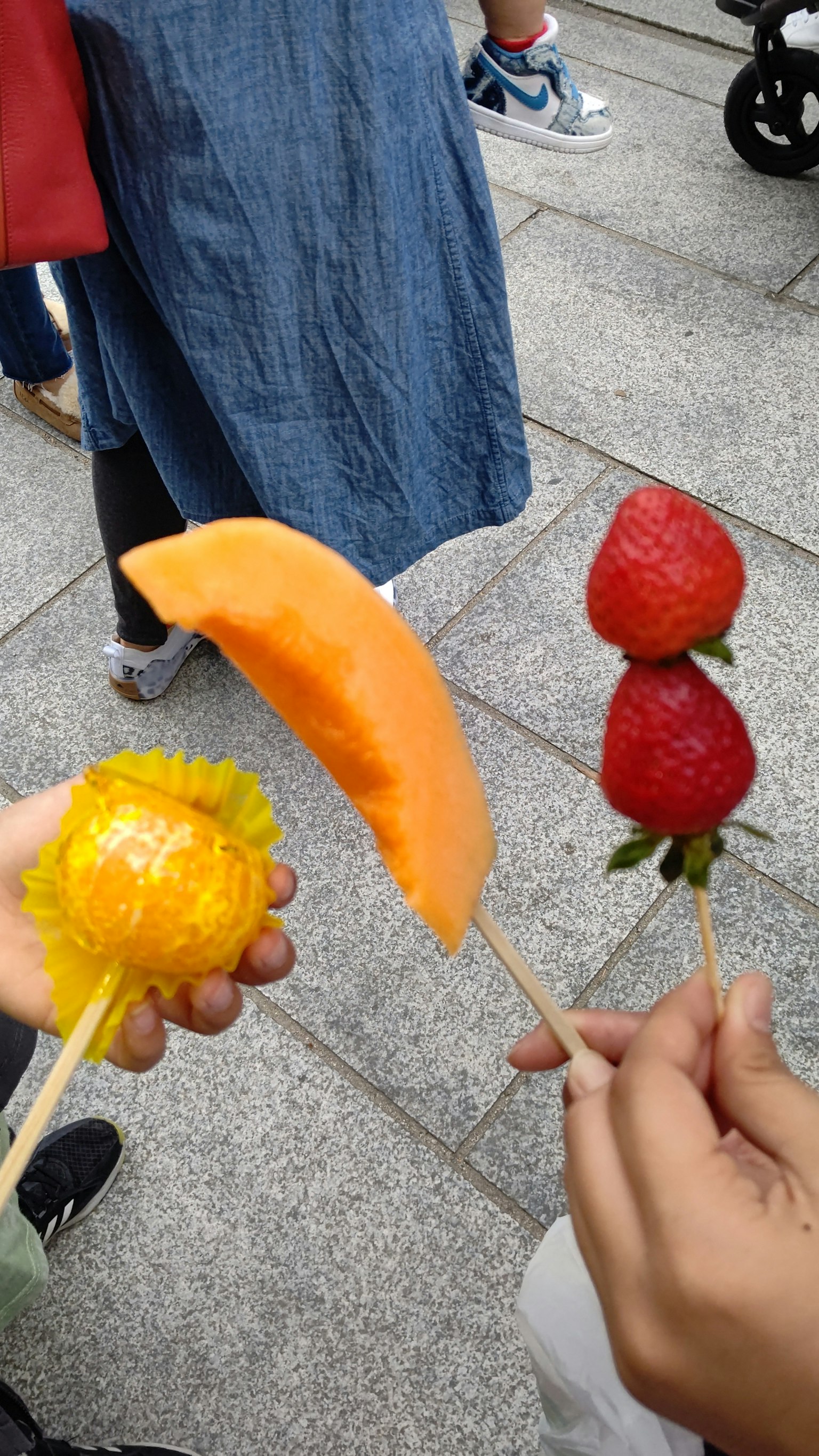 手中握着彩色水果串