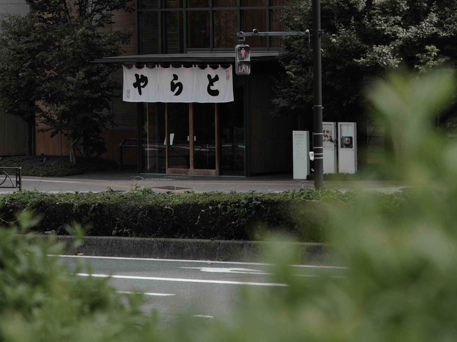 ฉากถนนเงียบที่มีป้ายสำหรับร้านอาหารชื่อ Yaradō