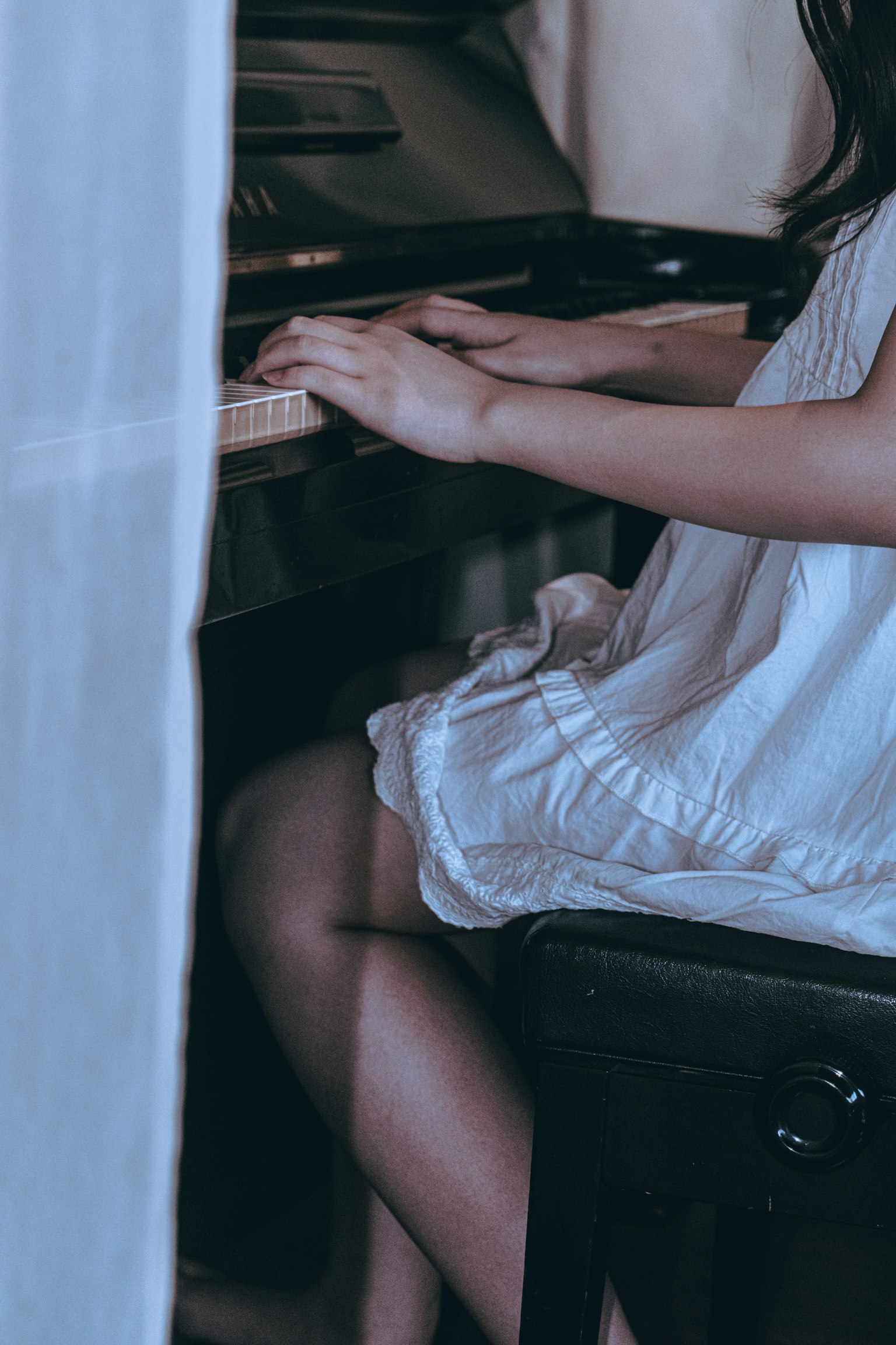 ピアノを弾いている少女の手と足が見えるシーン