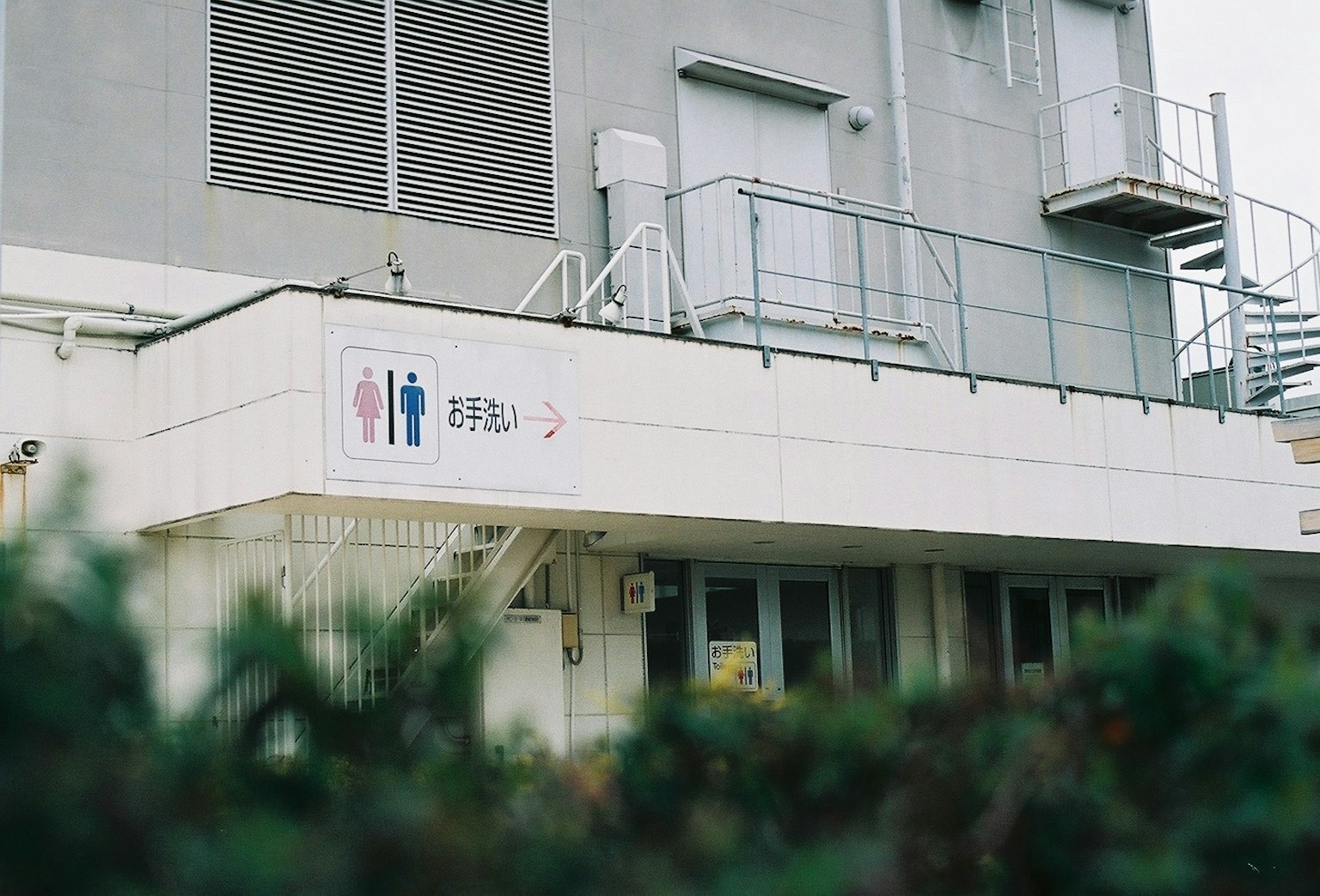 白色建築外觀，帶有男女廁所標誌