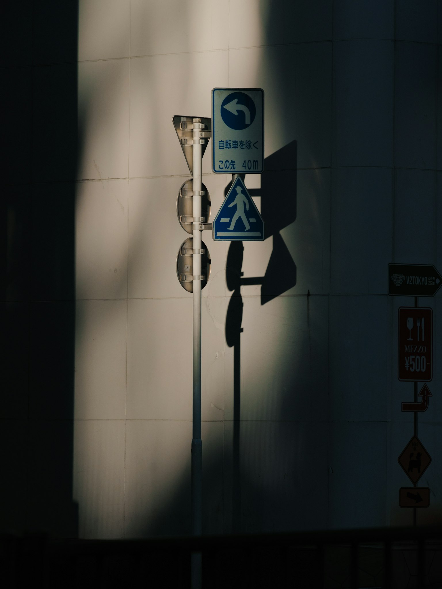 Señales de tráfico proyectando sombras en una pared
