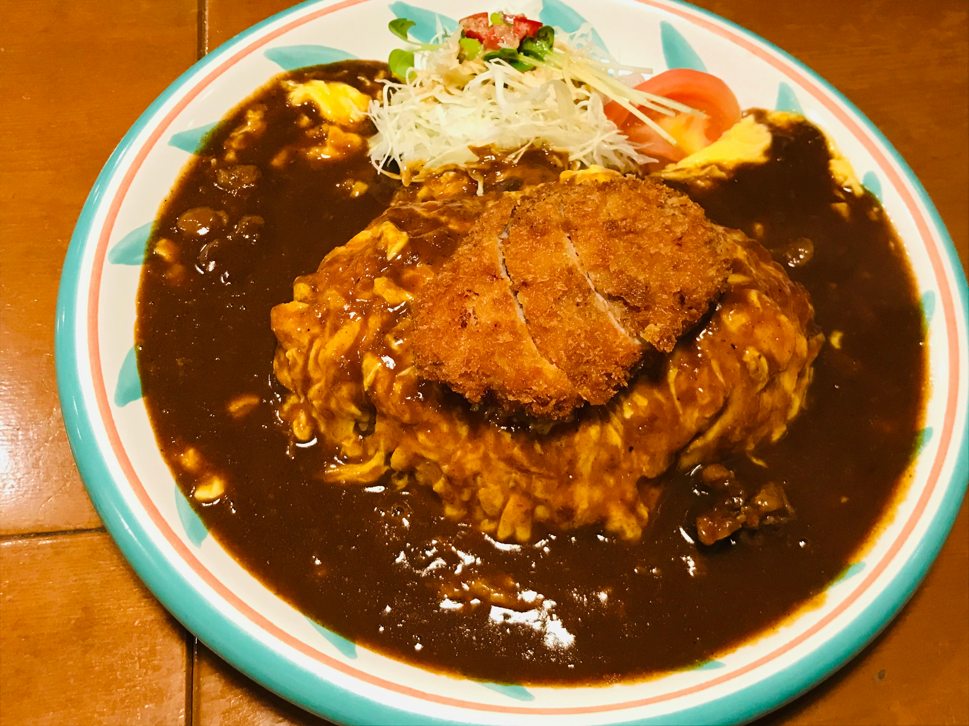 カレーソースの上にのったとんかつ定食の皿