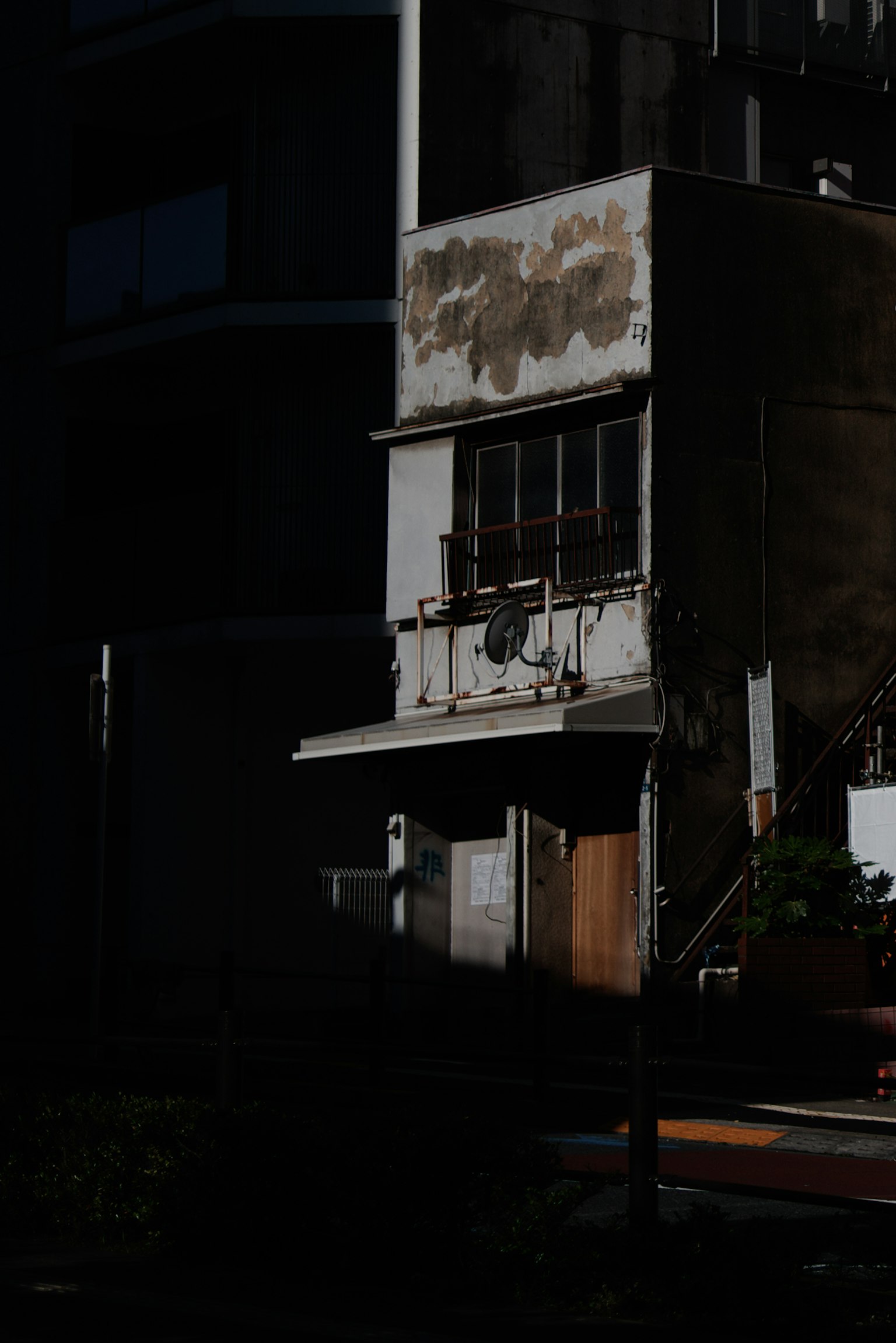 Exterior de un viejo edificio en una esquina de calle poco iluminada