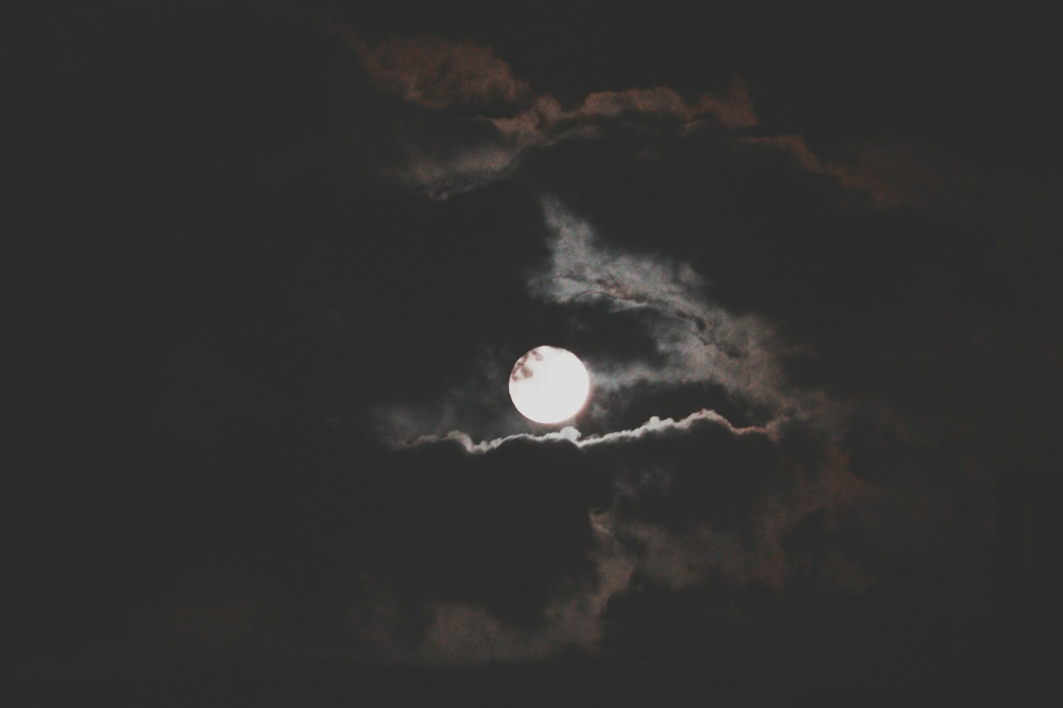 Luna piena luminosa che brilla tra nuvole scure
