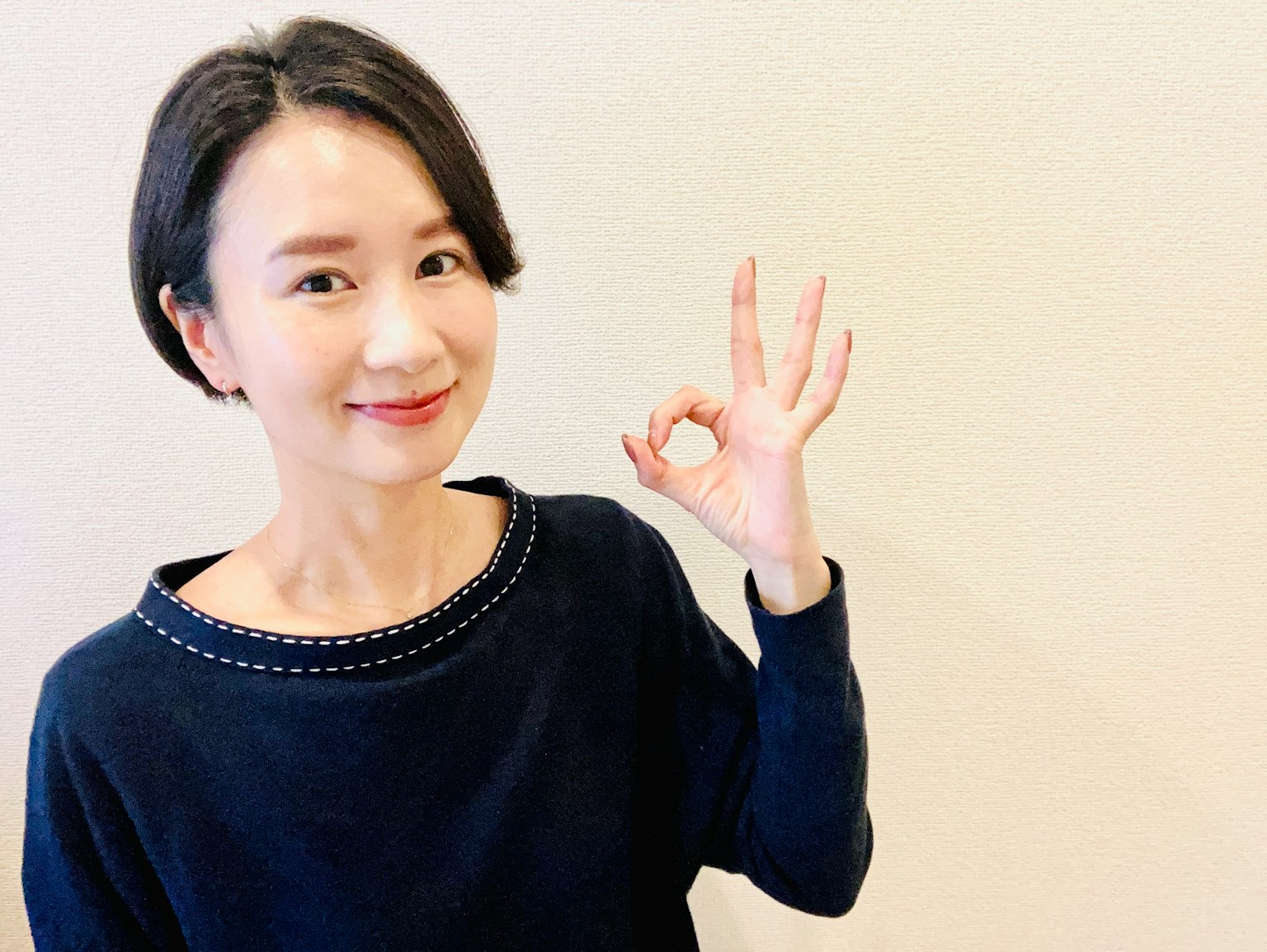 一位微笑的女性做出OK手势