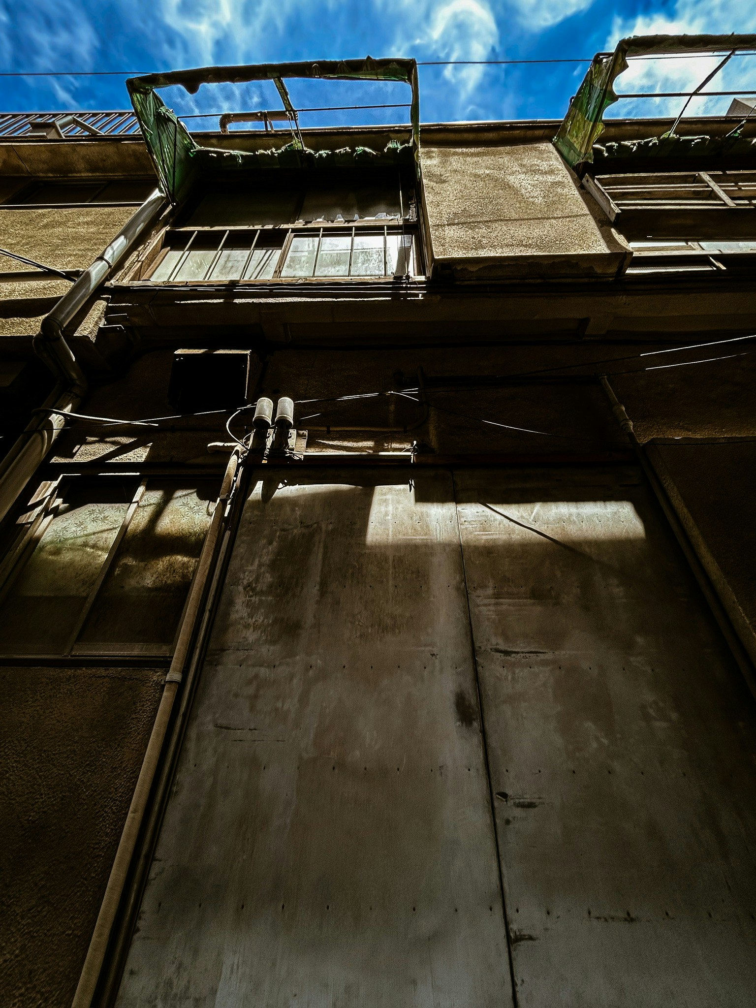 vista en contrapicado de una fachada antigua y ventanas contra el cielo