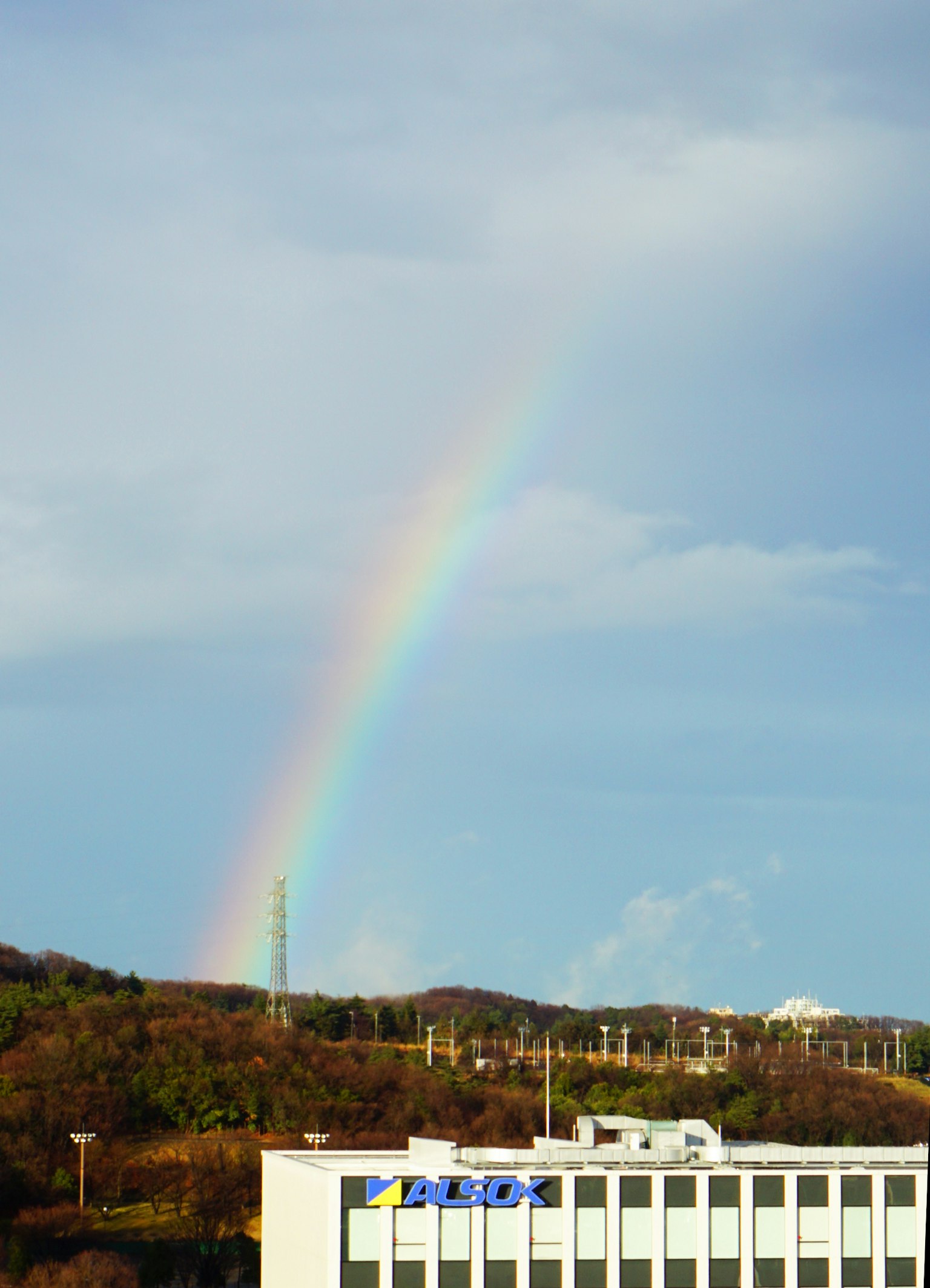 Un arcobaleno sopra un cielo blu e colline verdi