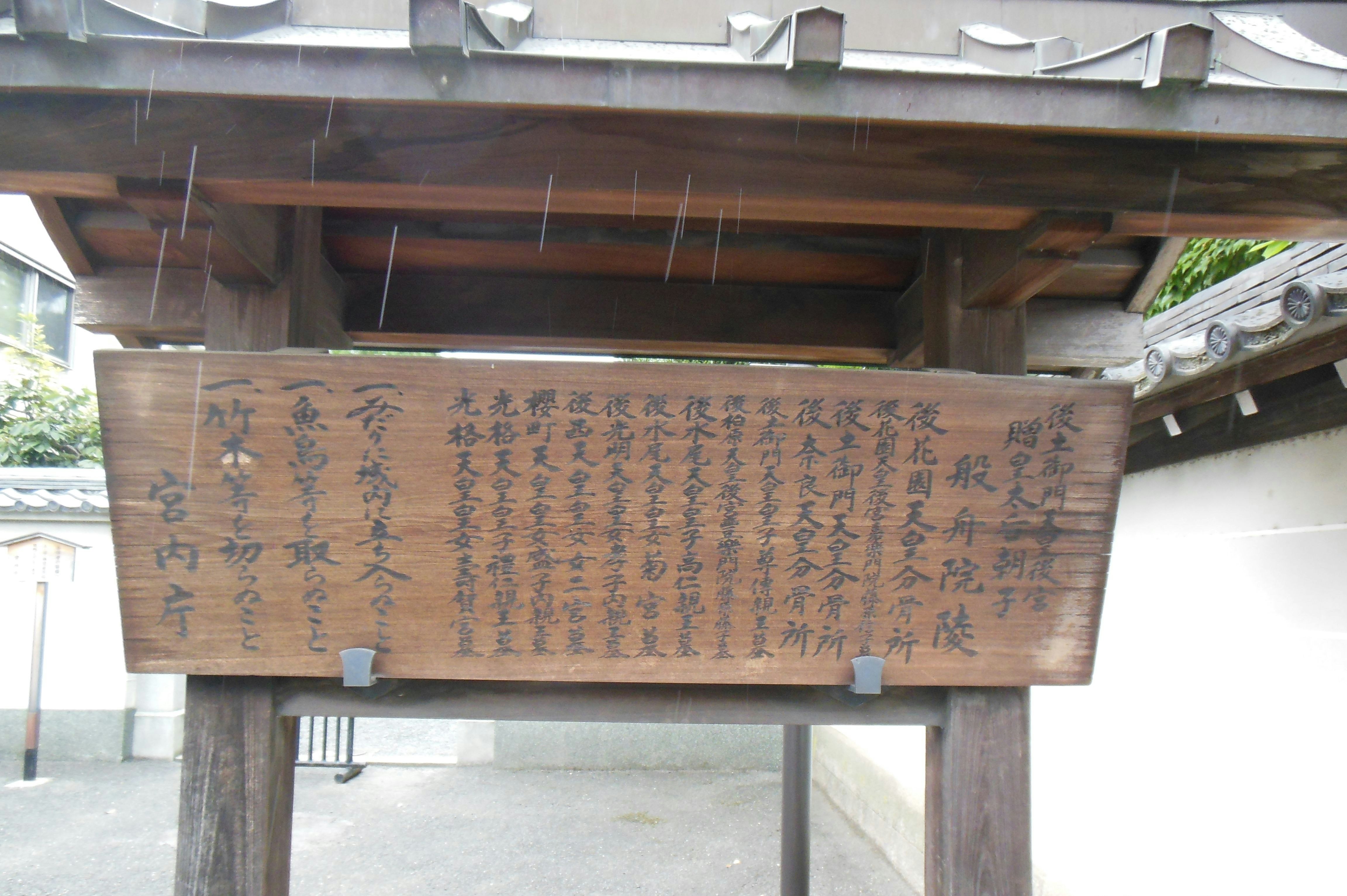 Japanese characters on a wooden sign at a shrine entrance