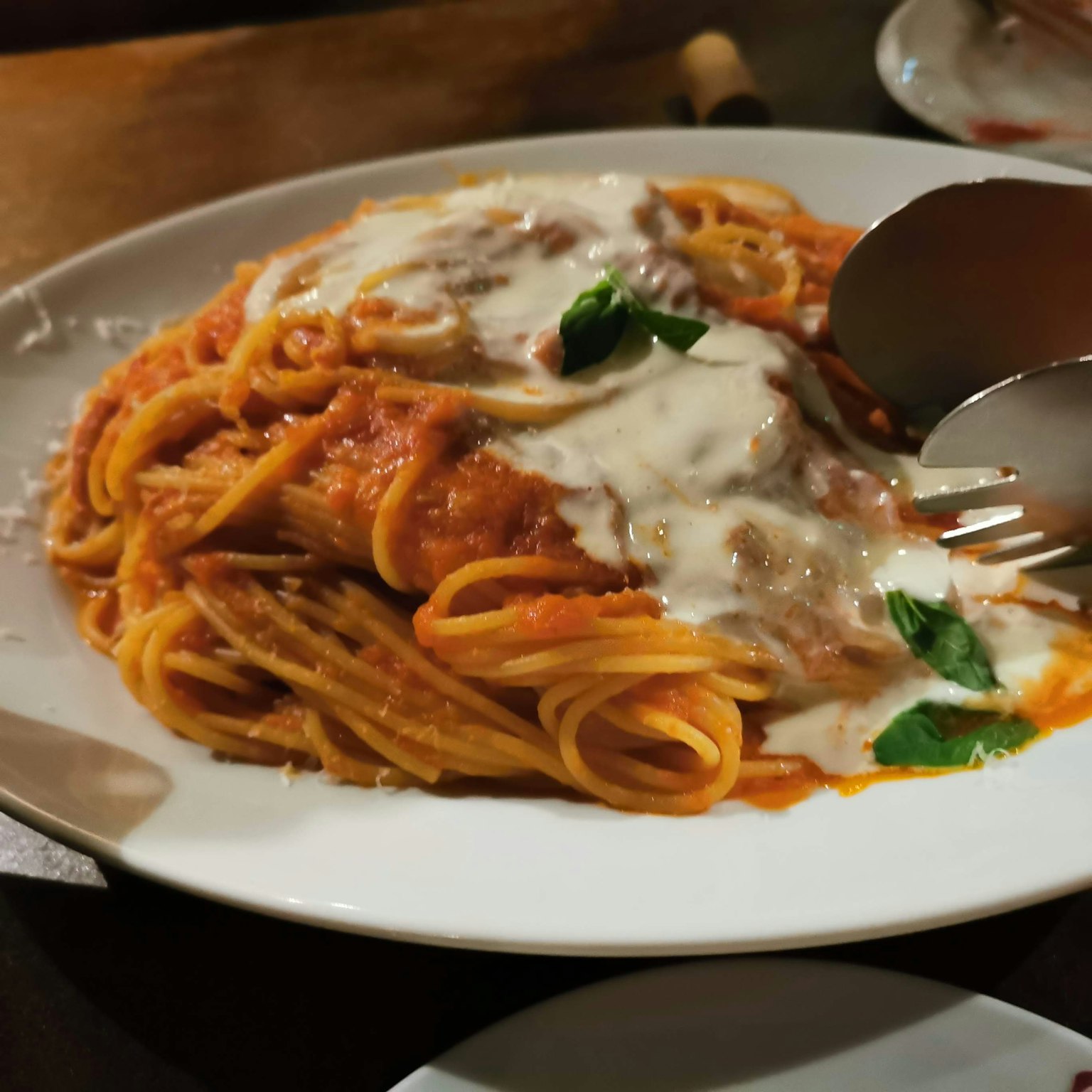 Piring spaghetti dengan saus krim dan basil di atasnya